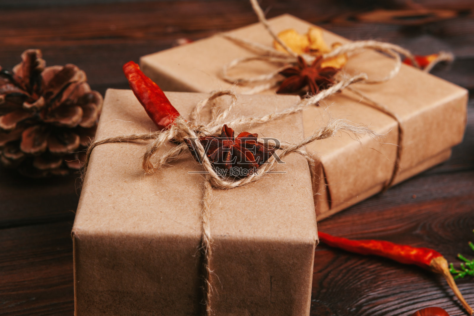 圣诞组成。圣诞礼物，针织毯子，松果，冷杉树枝在木制背景。照片摄影图片