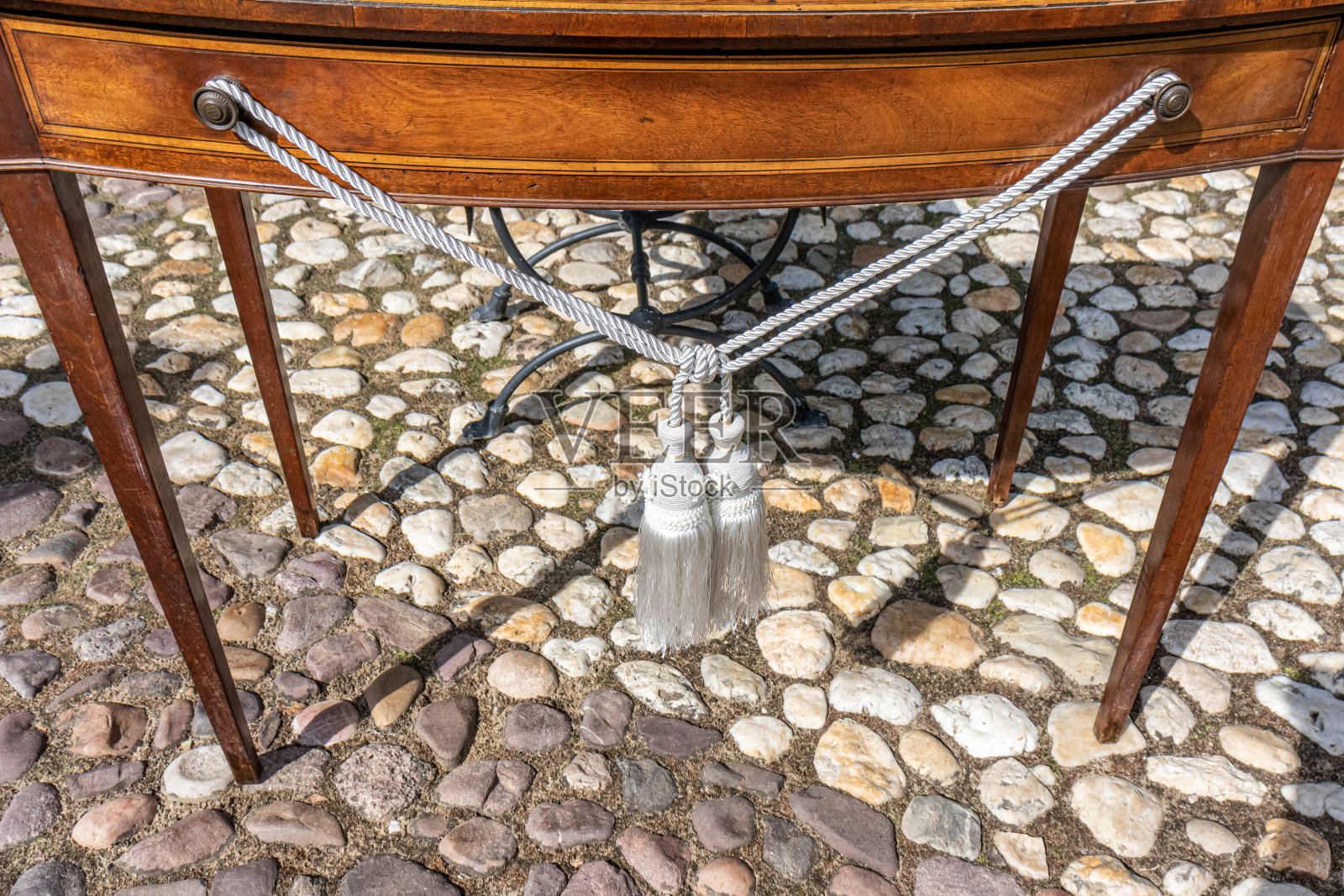 木制的桌子，上面有两条白色和金色的缎带，上面挂着小花照片摄影图片