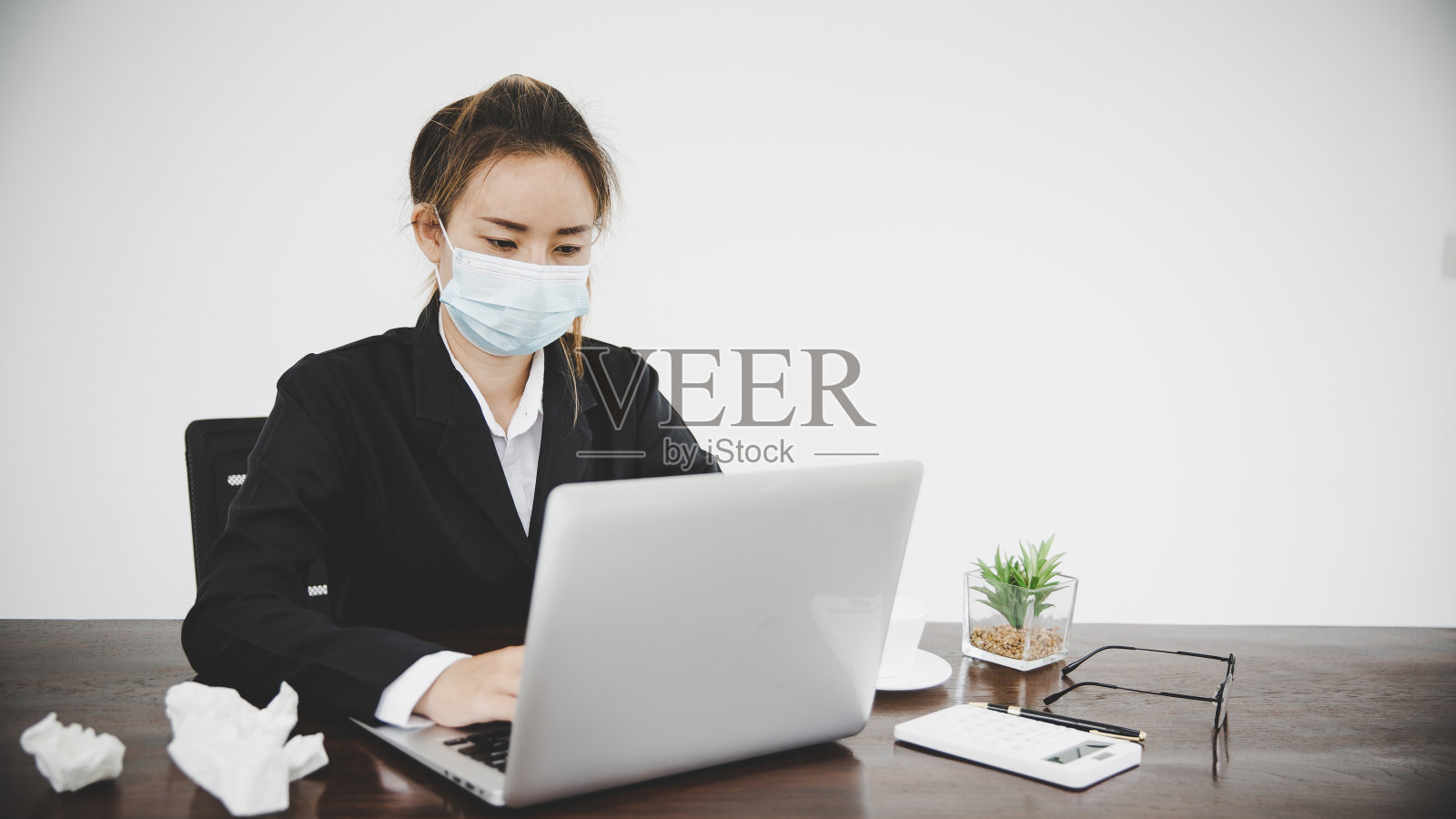 患病的年轻亚洲女商人戴着防护口罩照片摄影图片