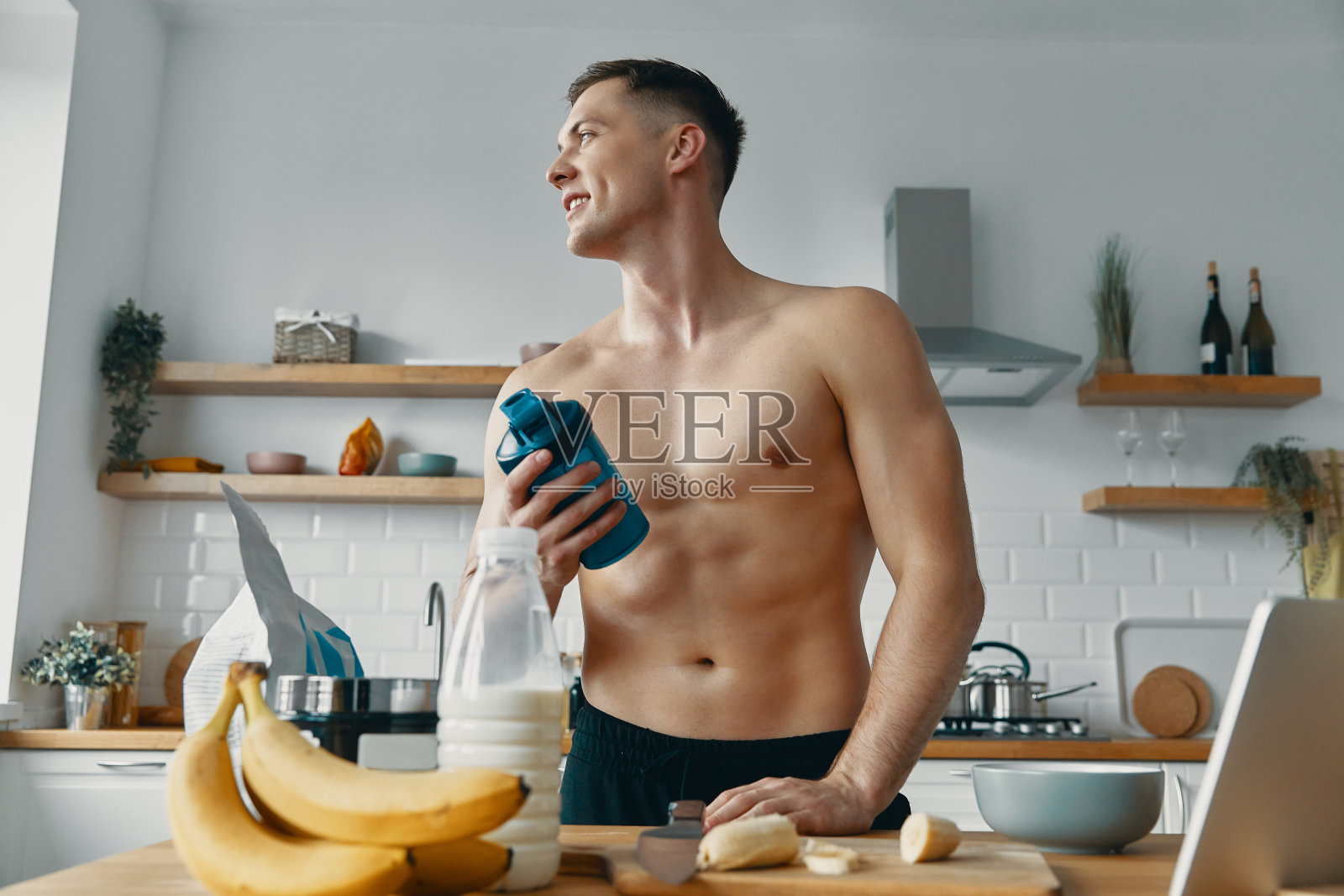 快乐的年轻人站在厨房准备蛋白质饮料照片摄影图片