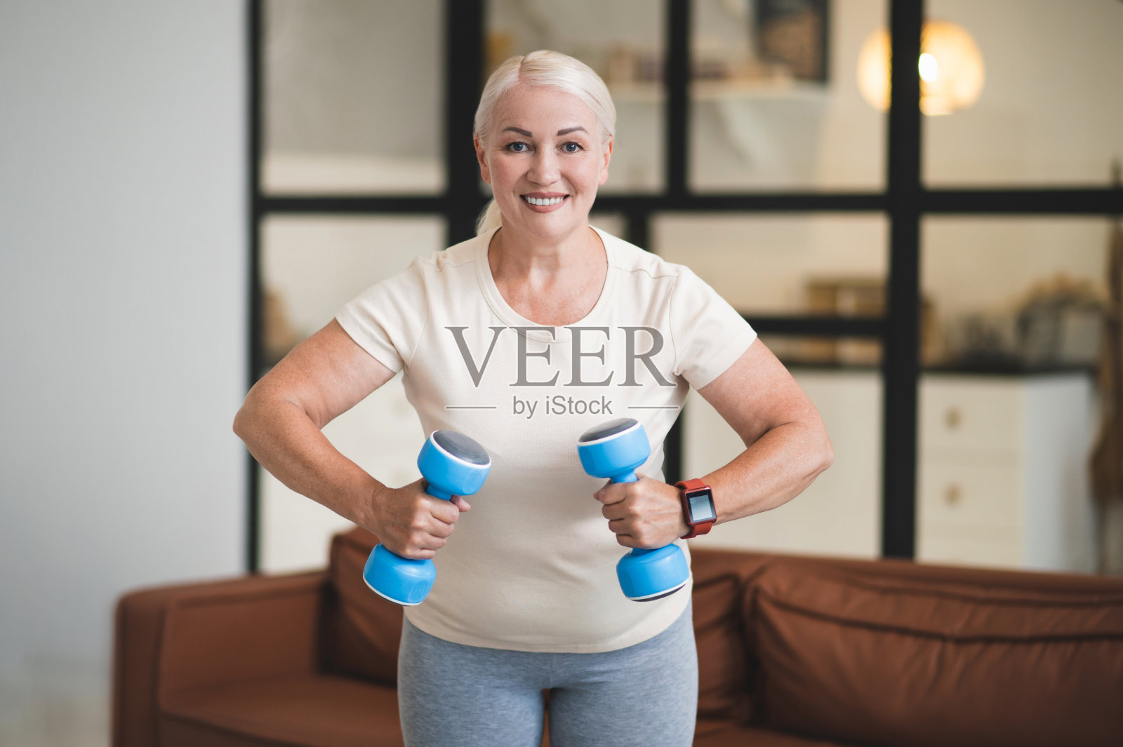 快乐的女士在室内用手举重锻炼照片摄影图片