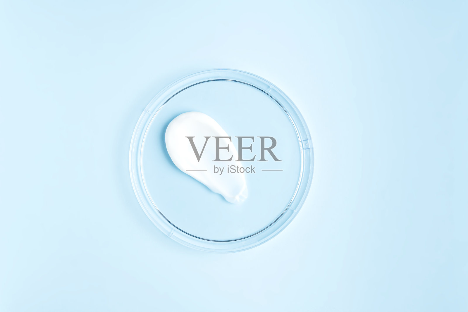 白色化妆品面霜或身体润肤乳在柔和的蓝色背景在培养皿。乳脂质感的卫生、护肤产品。美脸霜涂抹色板上的色彩背景照片摄影图片