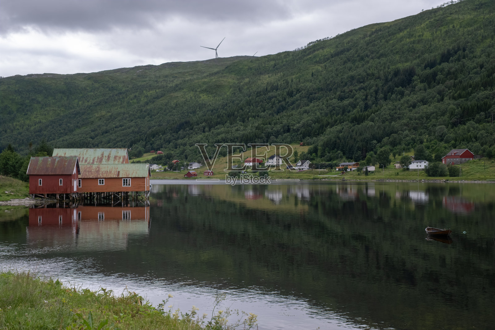 挪威美丽的风景。Nordland。Kvaloya岛Sorfjorden的吊脚屋上红色房屋的美丽风景。背景是峡湾上的船和山。有选择性的重点照片摄影图片
