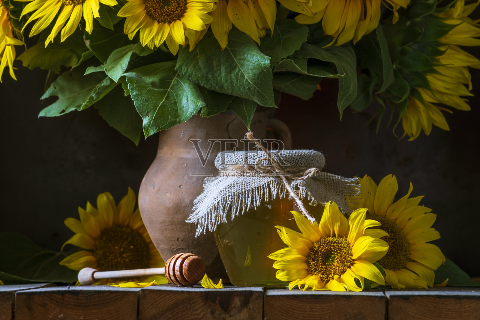 有机向日葵蜂蜜透明罐用粗麻袋餐巾盖勺理念健康饮食，老木背景锅静物暗食玻璃碗。照片摄影图片