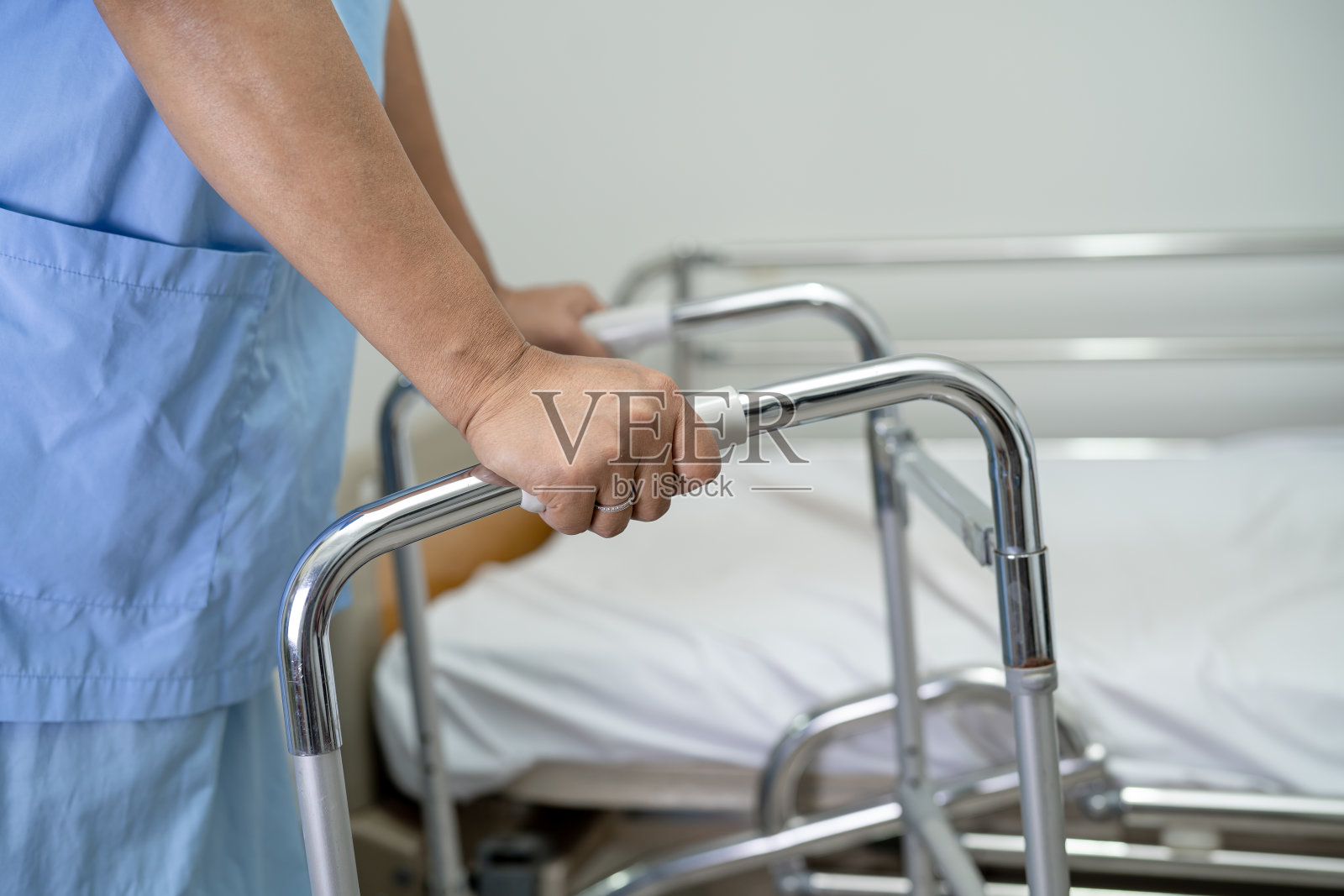 亚洲女性病人在护理医院病房用助行器散步，健康强烈的医疗理念照片摄影图片