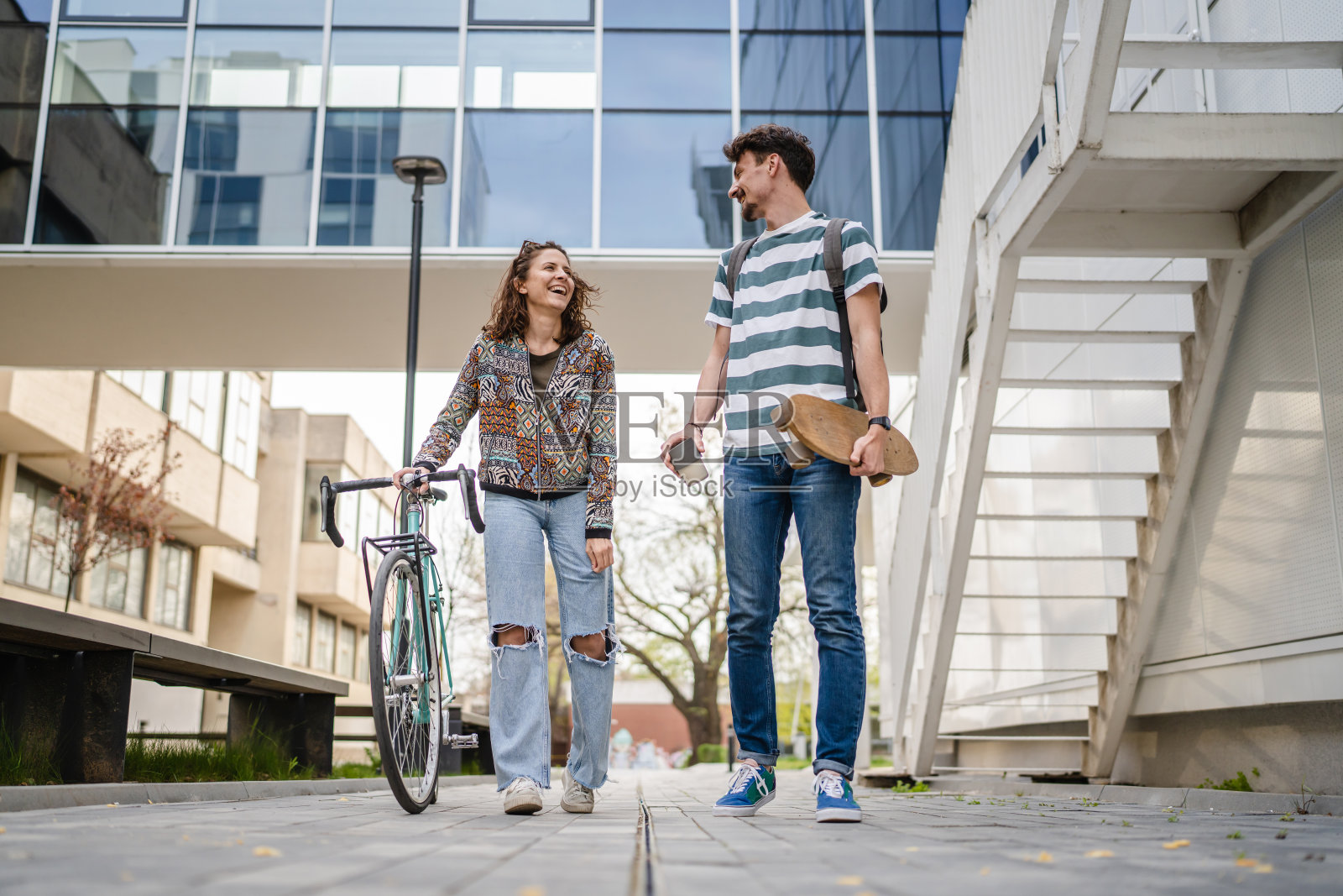现代夫妻男女学生在白天户外交谈照片摄影图片