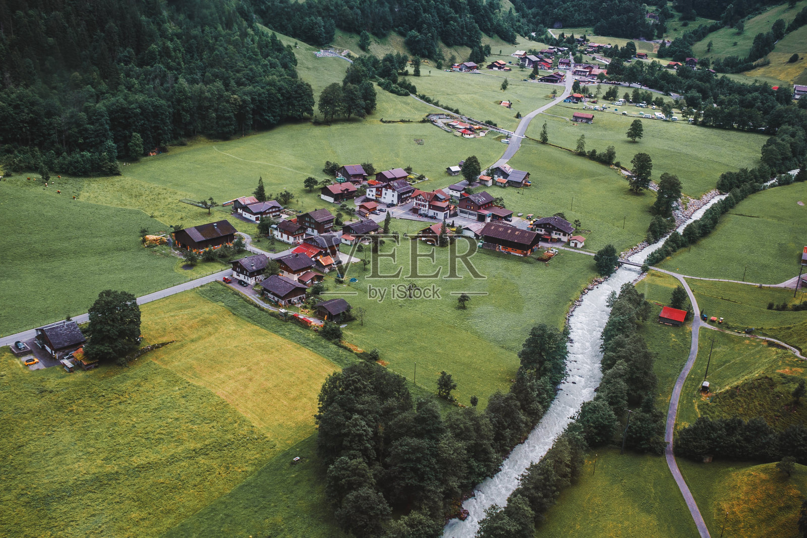 Lauterbrunnen,瑞士少女峰。瑞士阿尔卑斯山。舒适的小村庄在山，河，木屋，树木，从上面的道路。航空摄影。照片摄影图片