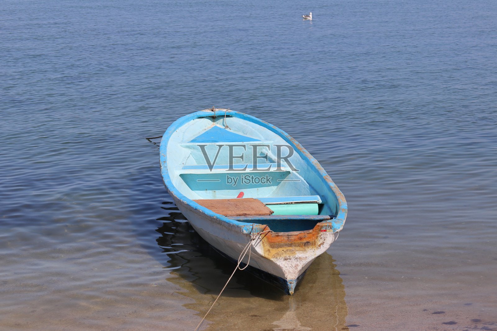 一艘没有发动机的小渔船停泊在海滩上。照片摄影图片