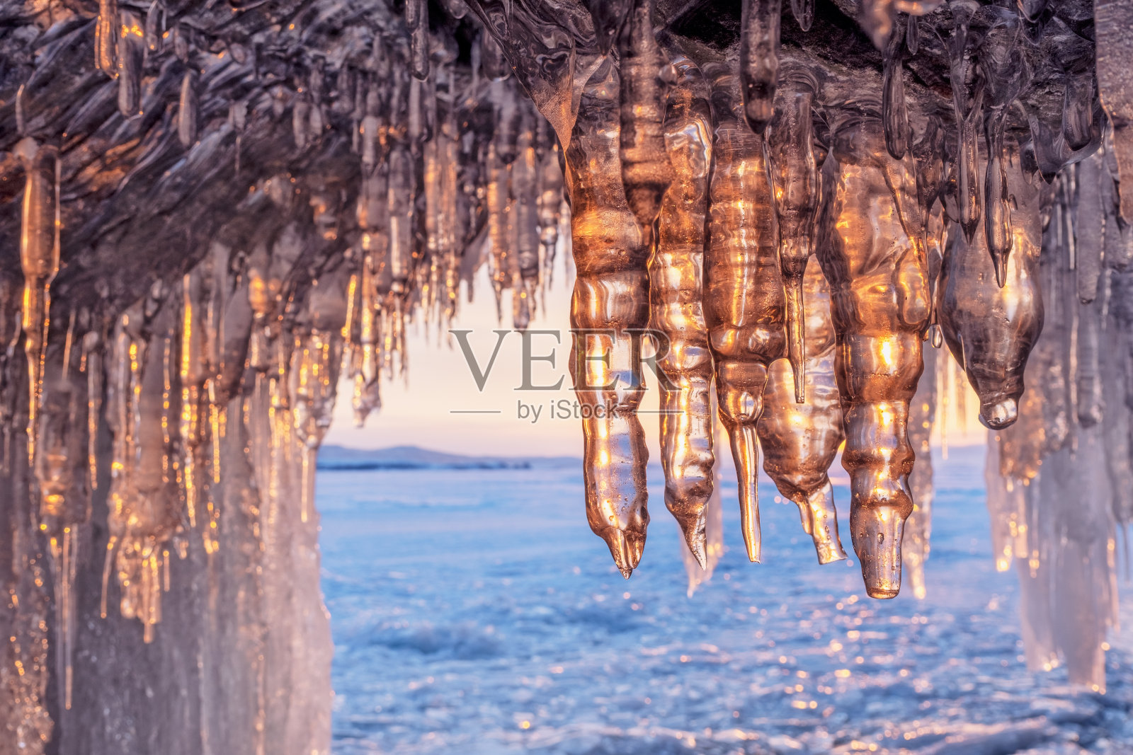 日落时贝加尔湖洞穴中的冰柱照片摄影图片