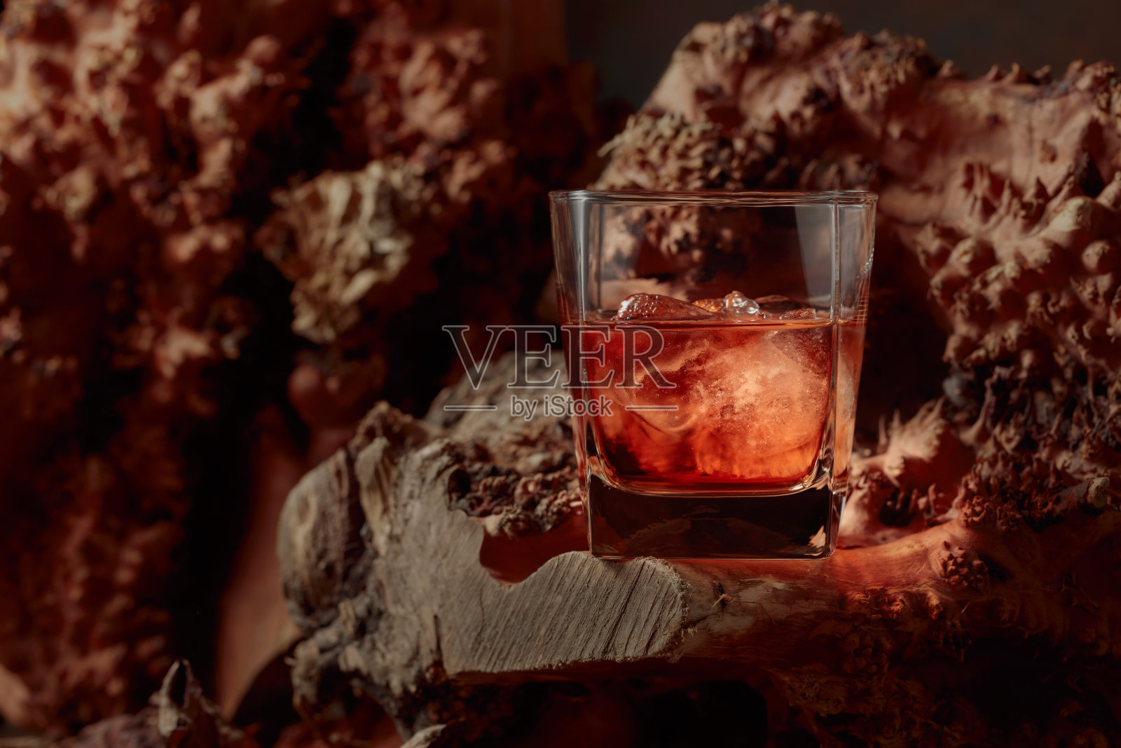 加冰的威士忌，放在干燥的陈年酒架上。照片摄影图片