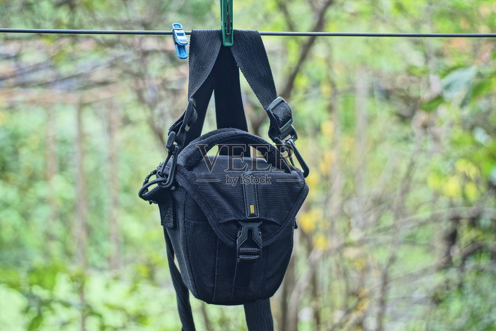 一个由织物制成的黑色袋子挂在电线上的安全带上照片摄影图片