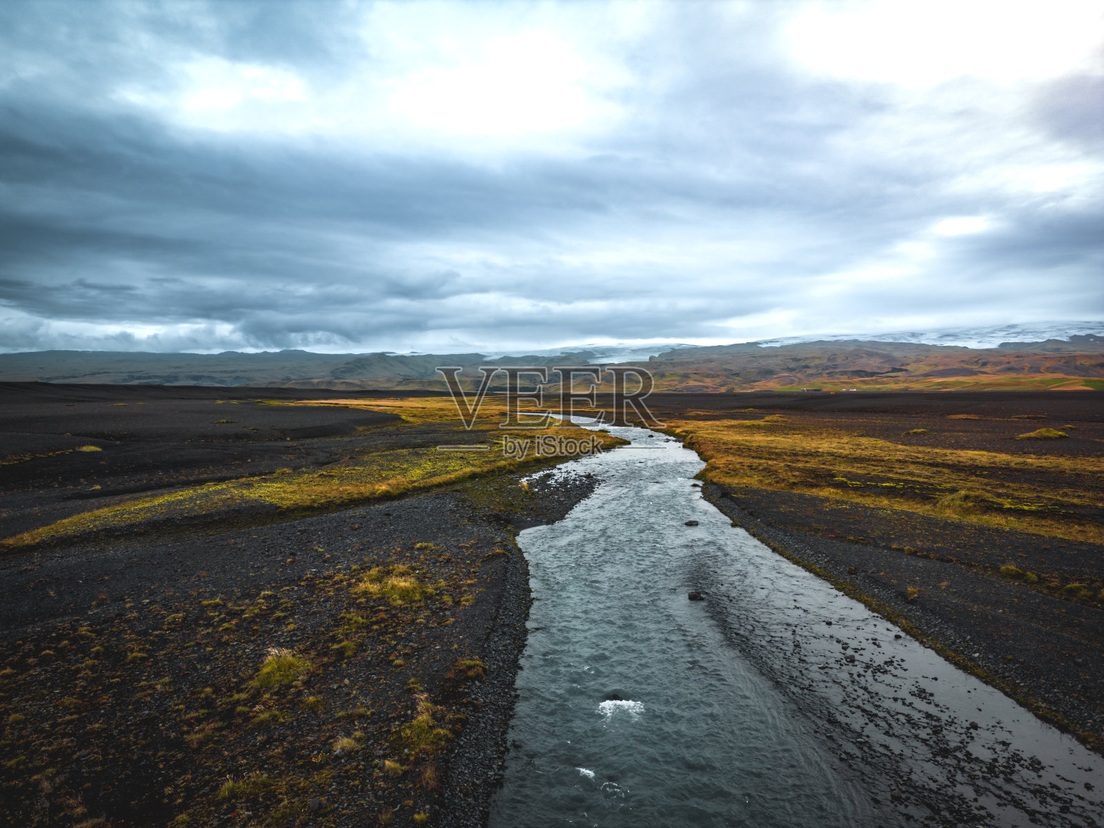 引人注目的黄河流经冰岛的黑沙，多云的天空照片摄影图片