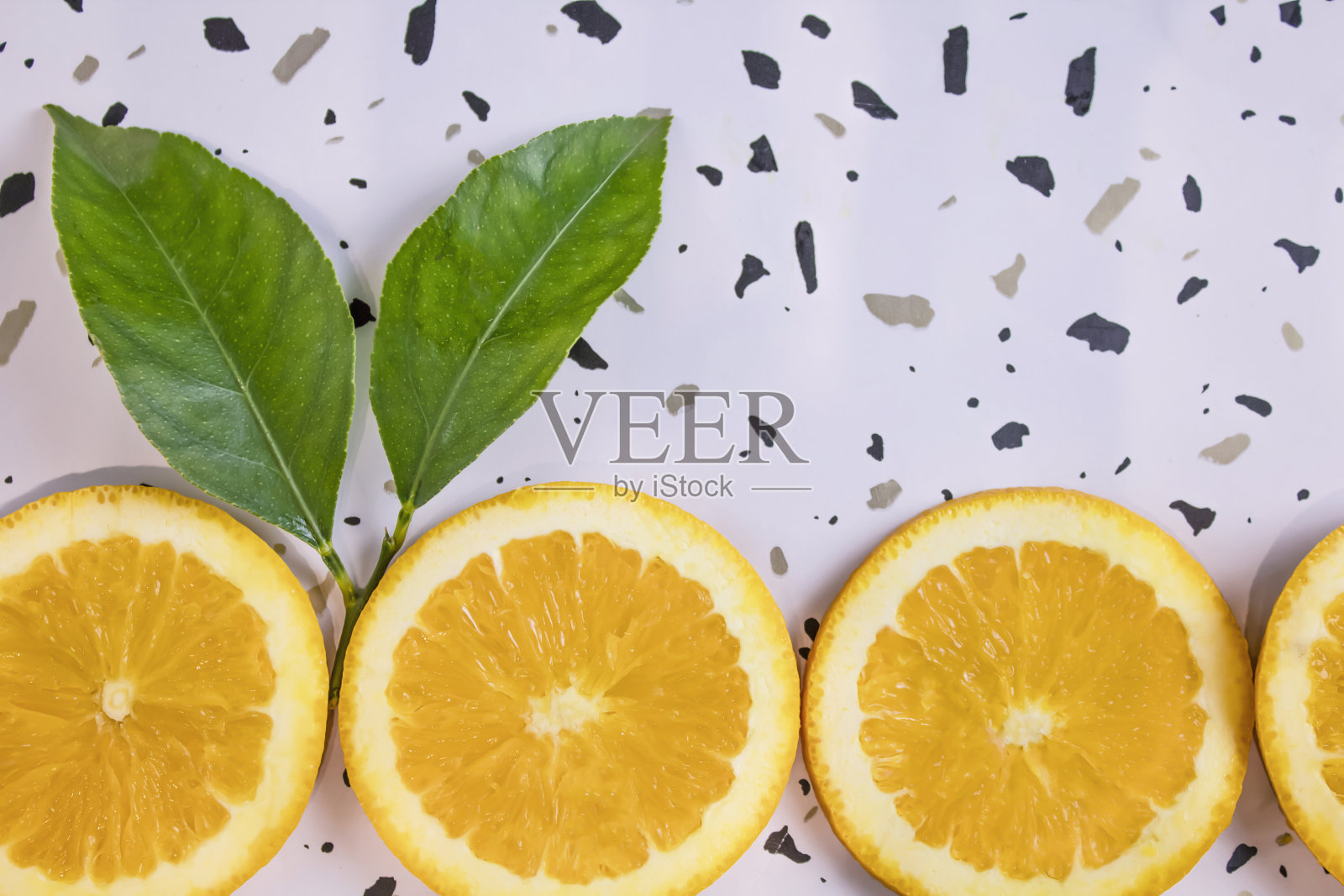 新鲜的橘片在白色水磨石背景。创意健康饮食理念。有机热带水果，精选重点照片摄影图片