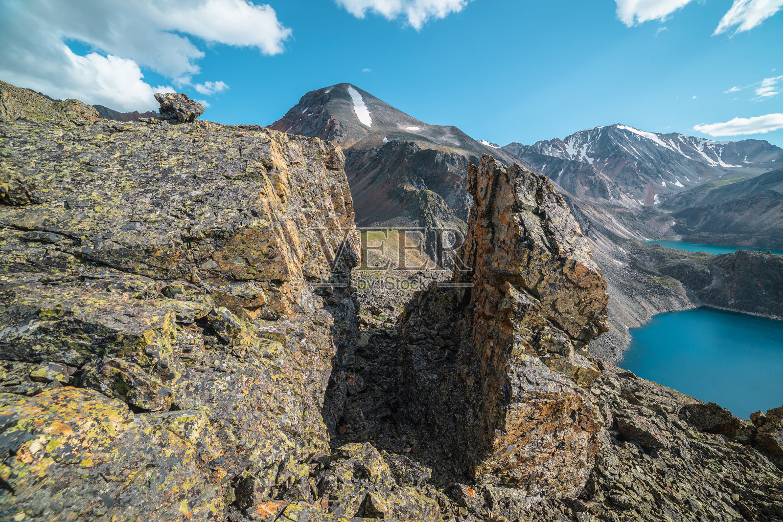 风景优美的景观，阳光照射下的石头离群点，在明亮的阳光下可以看到两个山湖和雪山。在晴朗的日子里，蓝色的天空下，有尖利的岩石和高山湖泊。照片摄影图片