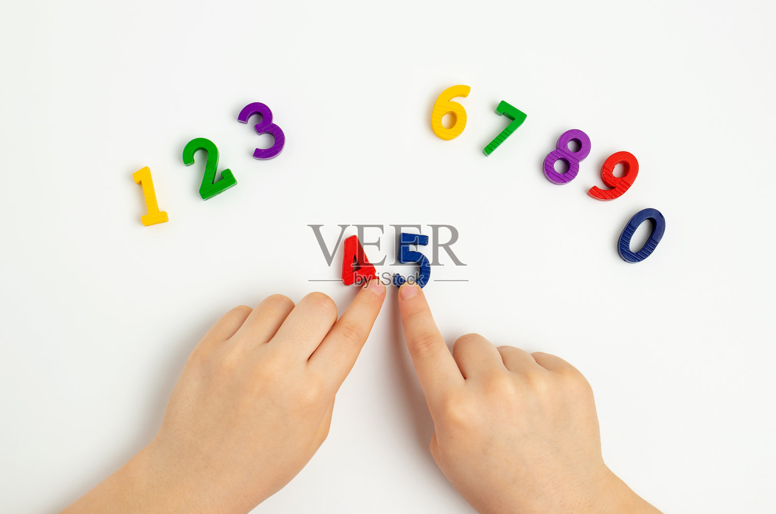 孩子们的手在白色的桌子上移动数字。学习颜色，从0数到10照片摄影图片