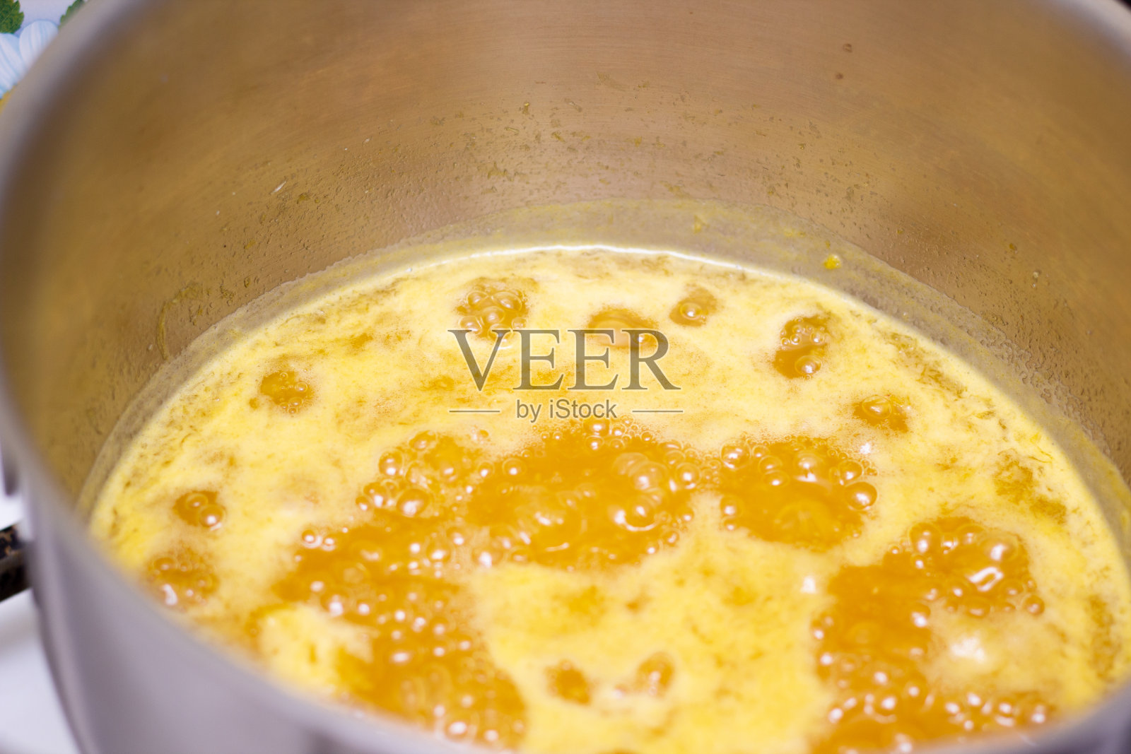 橙酱在平底锅里煮开。泡沫果酱。在家做果酱。橙果酱。果酱。果冻。照片摄影图片