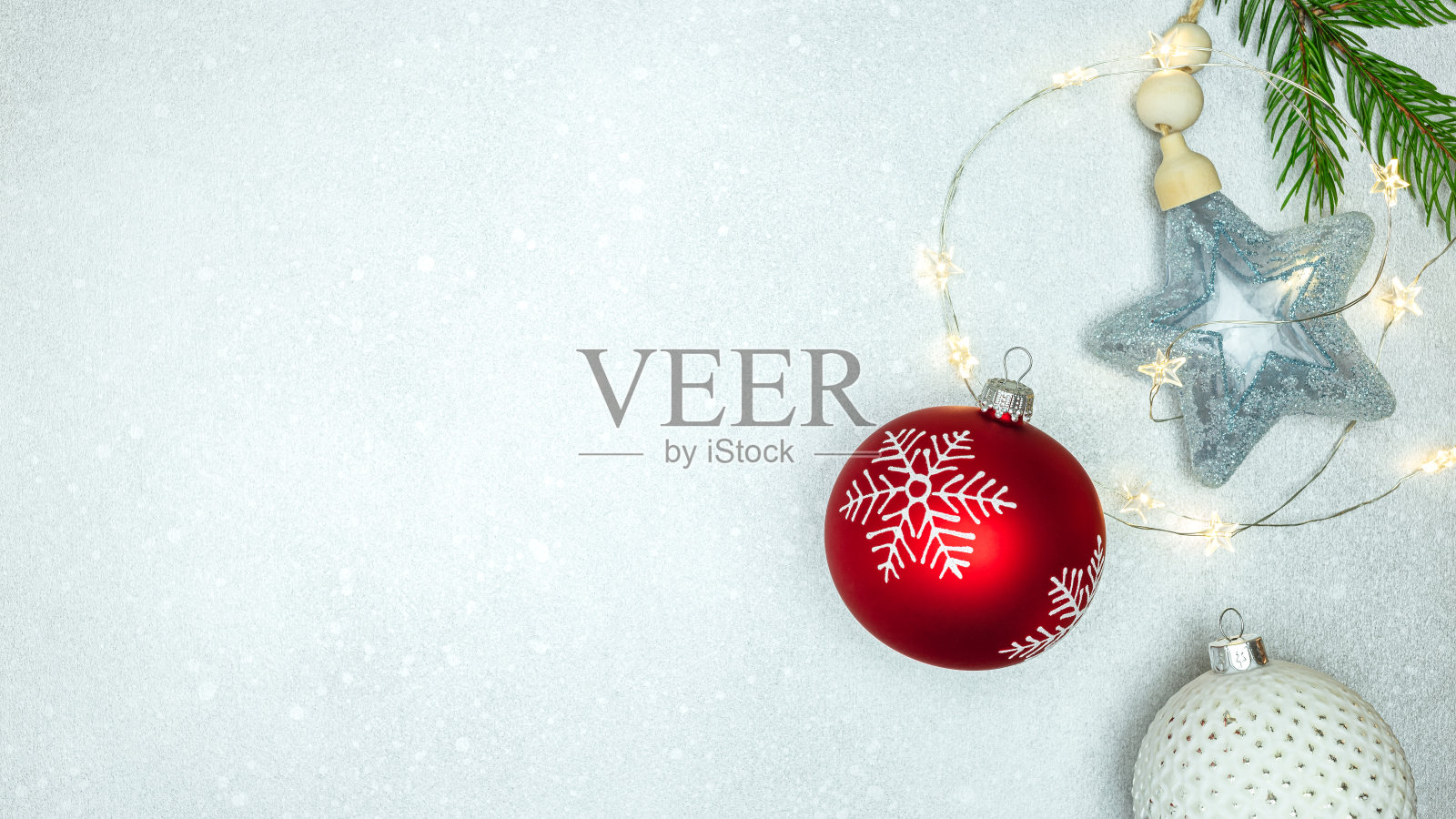 银色背景的新年装饰。圣诞树上挂着节日彩灯、玻璃球和星星照片摄影图片