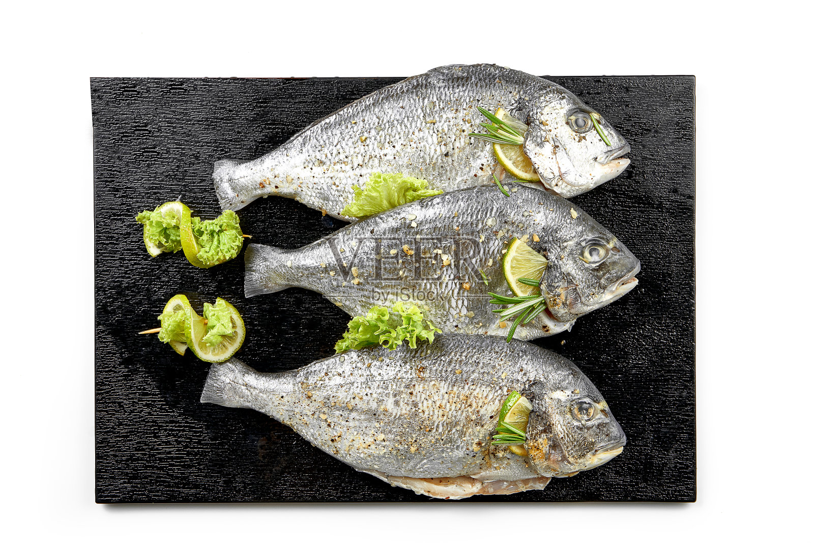 新鲜生的多拉多加香料，放在黑板上。准备做饭。白色背景。有选择性的重点照片摄影图片