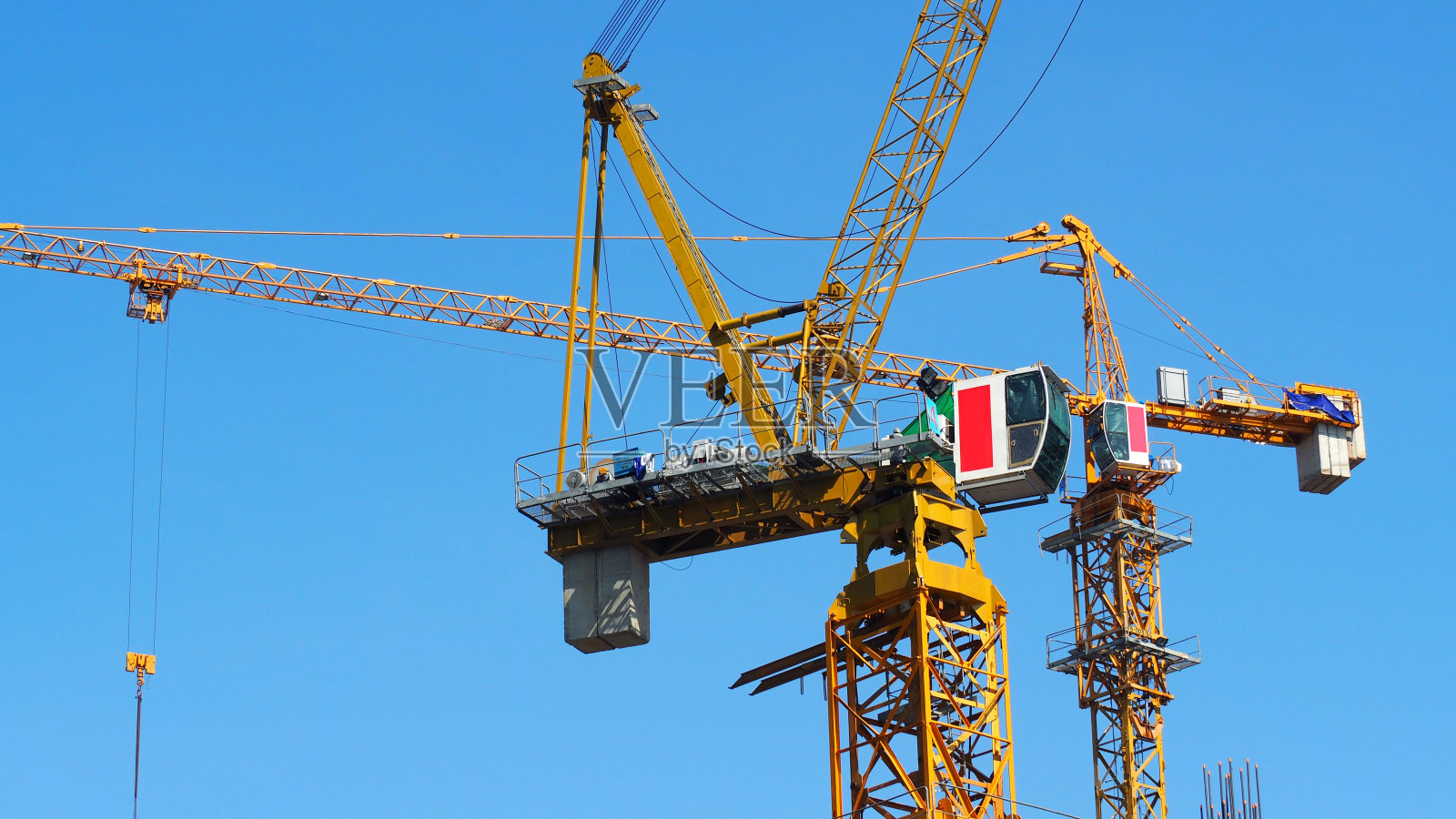 起重机在建筑工地工作，重钢材料，黄色和蓝色的天空照片摄影图片