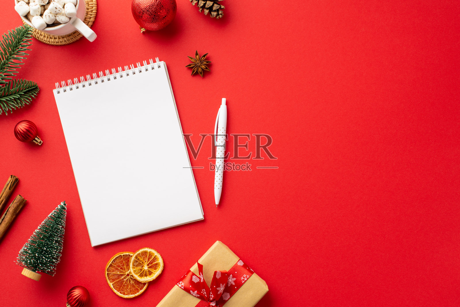 新年的概念。顶视图的照片记事本钢笔红色的小摆设杉树枝工艺纸礼盒杯可可和干柑橘片孤立的红色背景与空白照片摄影图片