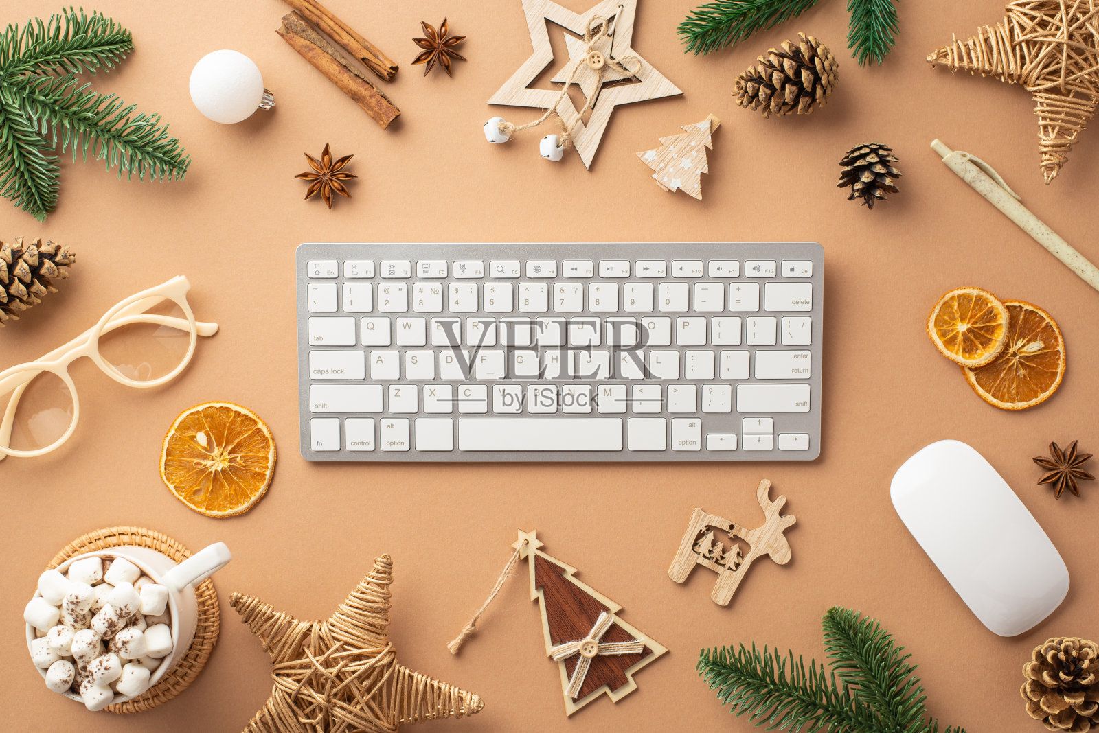 俯视图照片圣诞装饰键盘电脑鼠标木饰品柳条星星小饰物杯可可松果树枝眼镜肉桂干橙片在孤立的米色背景照片摄影图片