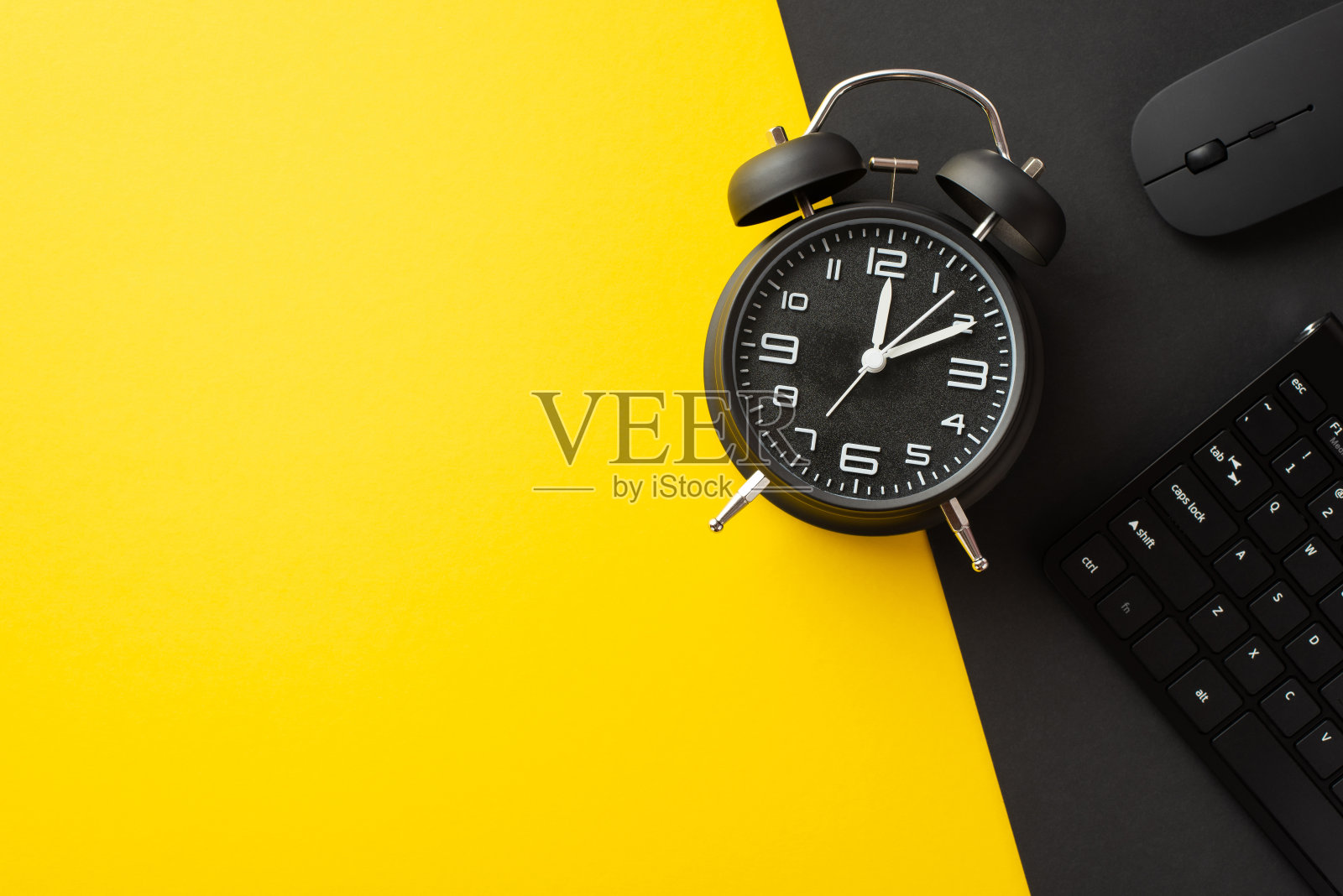 星期一的概念。俯视图照片的键盘，电脑鼠标和黑色闹钟在双色黄色和黑色的背景与空白照片摄影图片