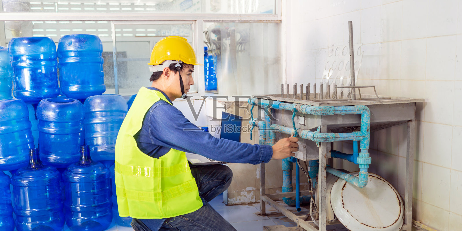 在饮水厂工作的工程师使用平板电脑检查和修理锅炉水到工厂水系统照片摄影图片