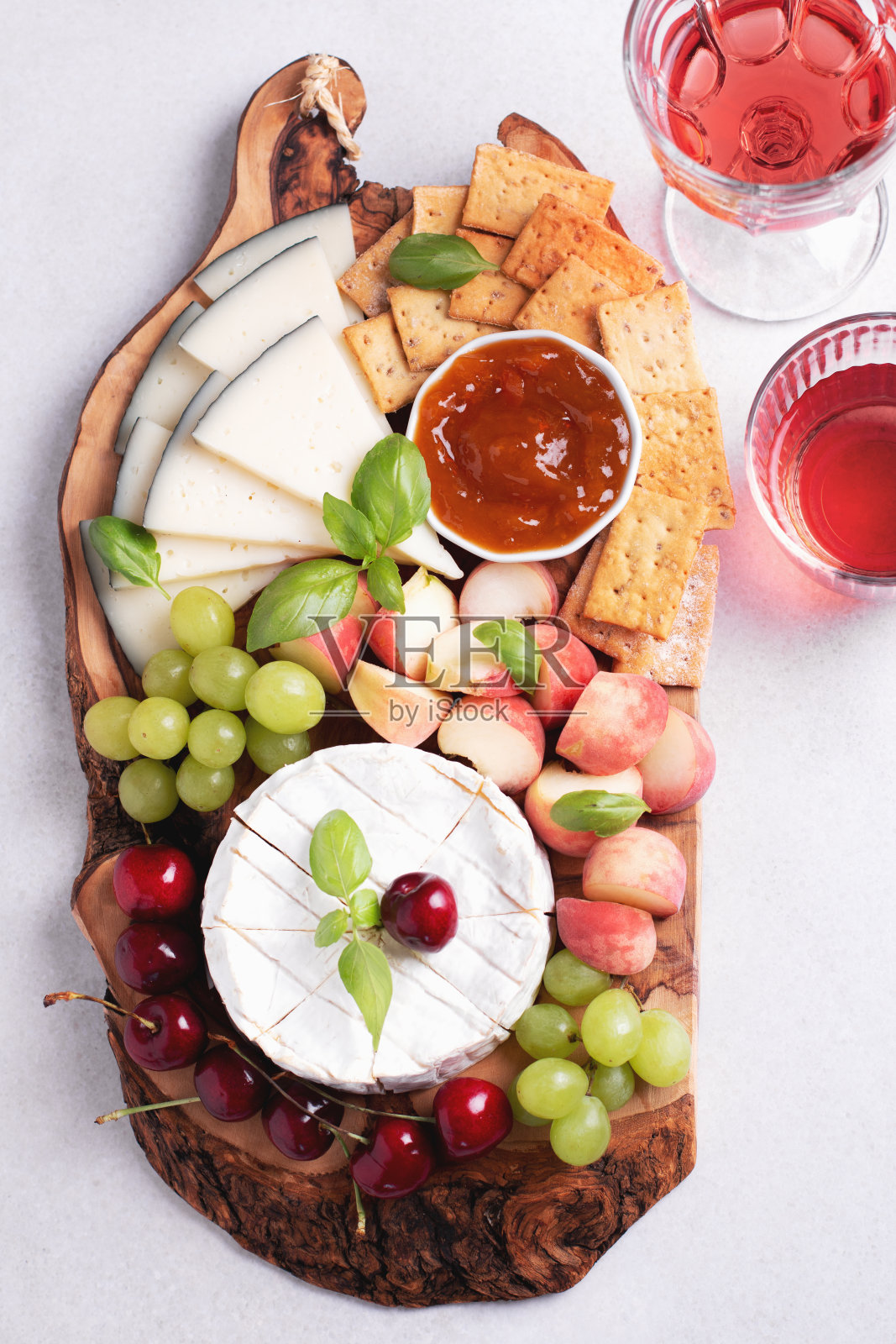 健康的地中海奶酪和水果板与玫瑰酒在浅色背景照片摄影图片