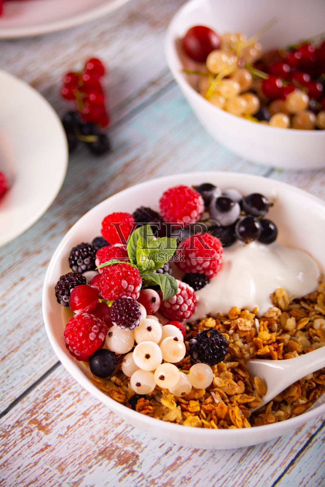 格兰诺拉麦片，麦片搭配酸奶或牛奶和新鲜浆果。健康的早餐概念。照片摄影图片