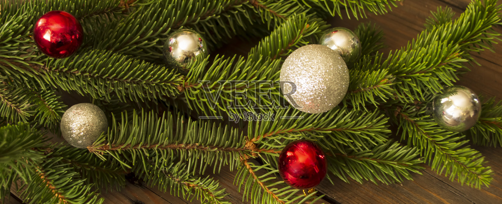 圣诞树上有白色和红色的圣诞球。珠宝首饰了。云杉的树枝上挂着红灰相间的球。照片摄影图片