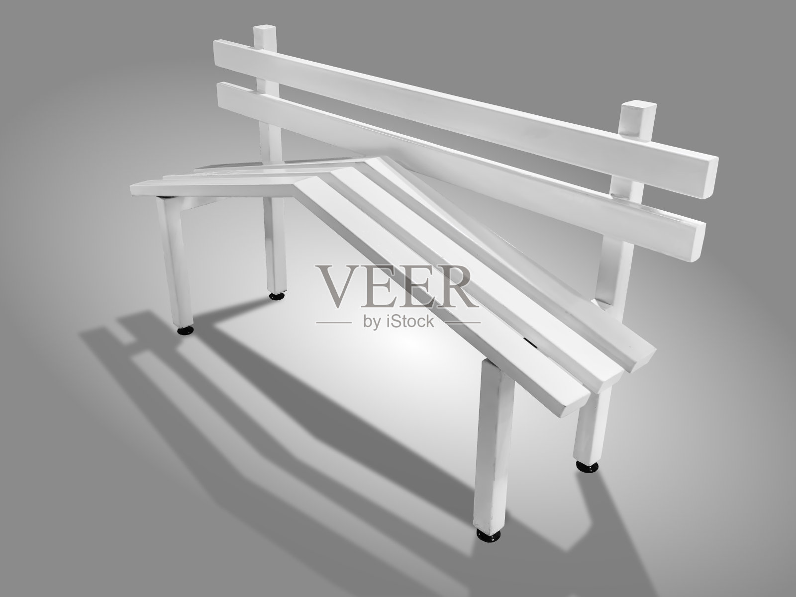 白色木质长凳，倾斜的木板孤立在灰色背景上照片摄影图片