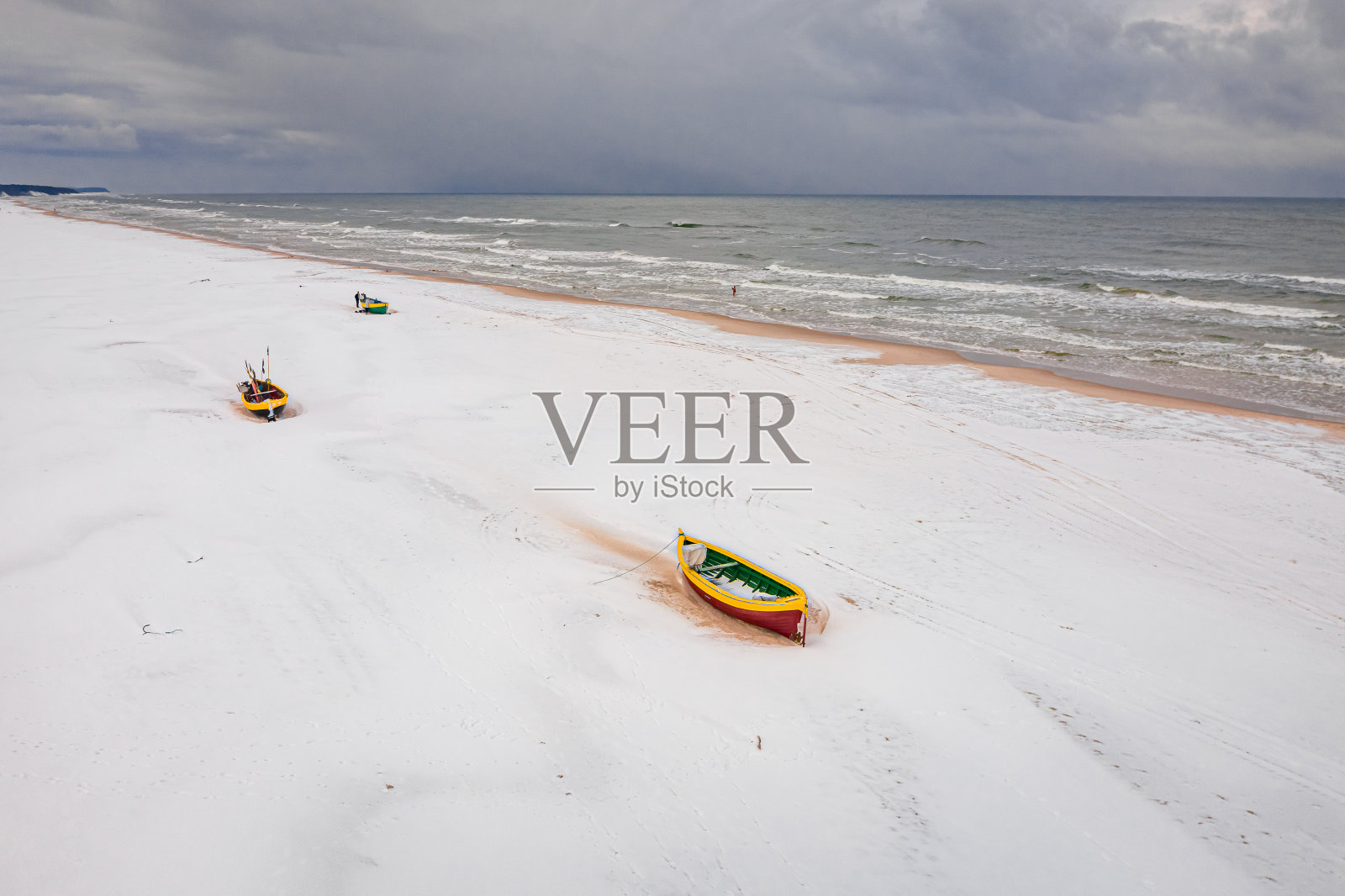 雪滩上的渔船。冬天的波罗的海。鸟瞰图照片摄影图片