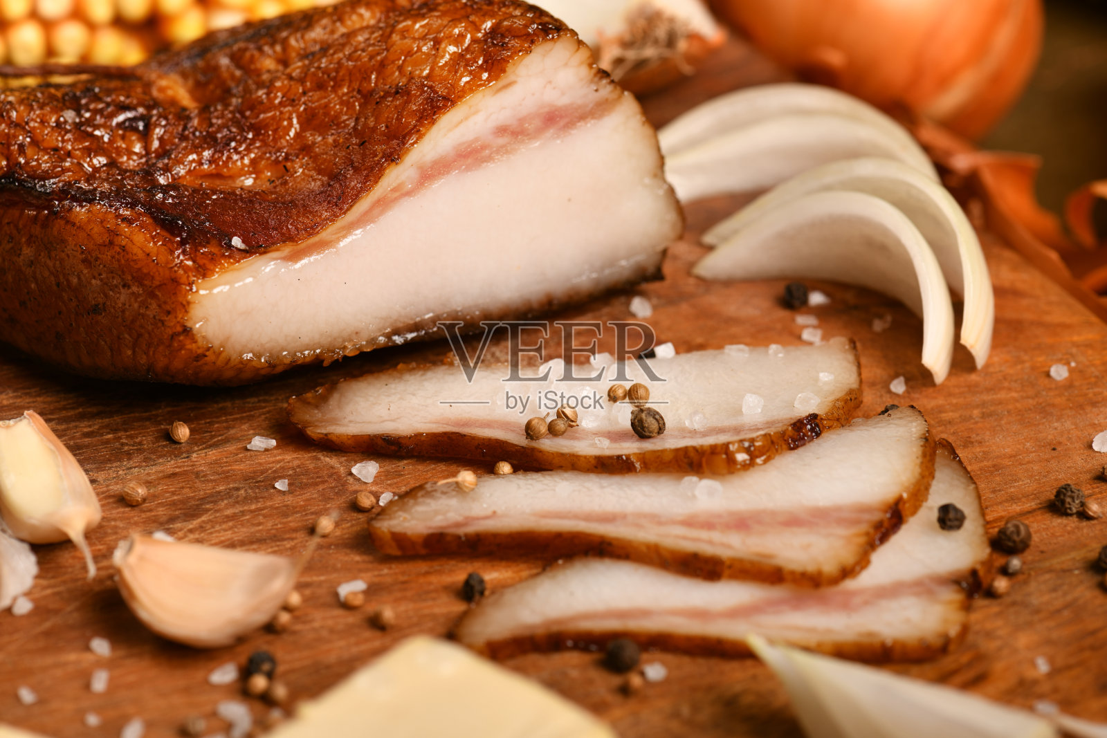 乡村风格的食物静物画在深色的木头背景上，切片的猪油和大蒜，玉米，盐和胡椒，新鲜蔬菜和健康食品的概念照片摄影图片