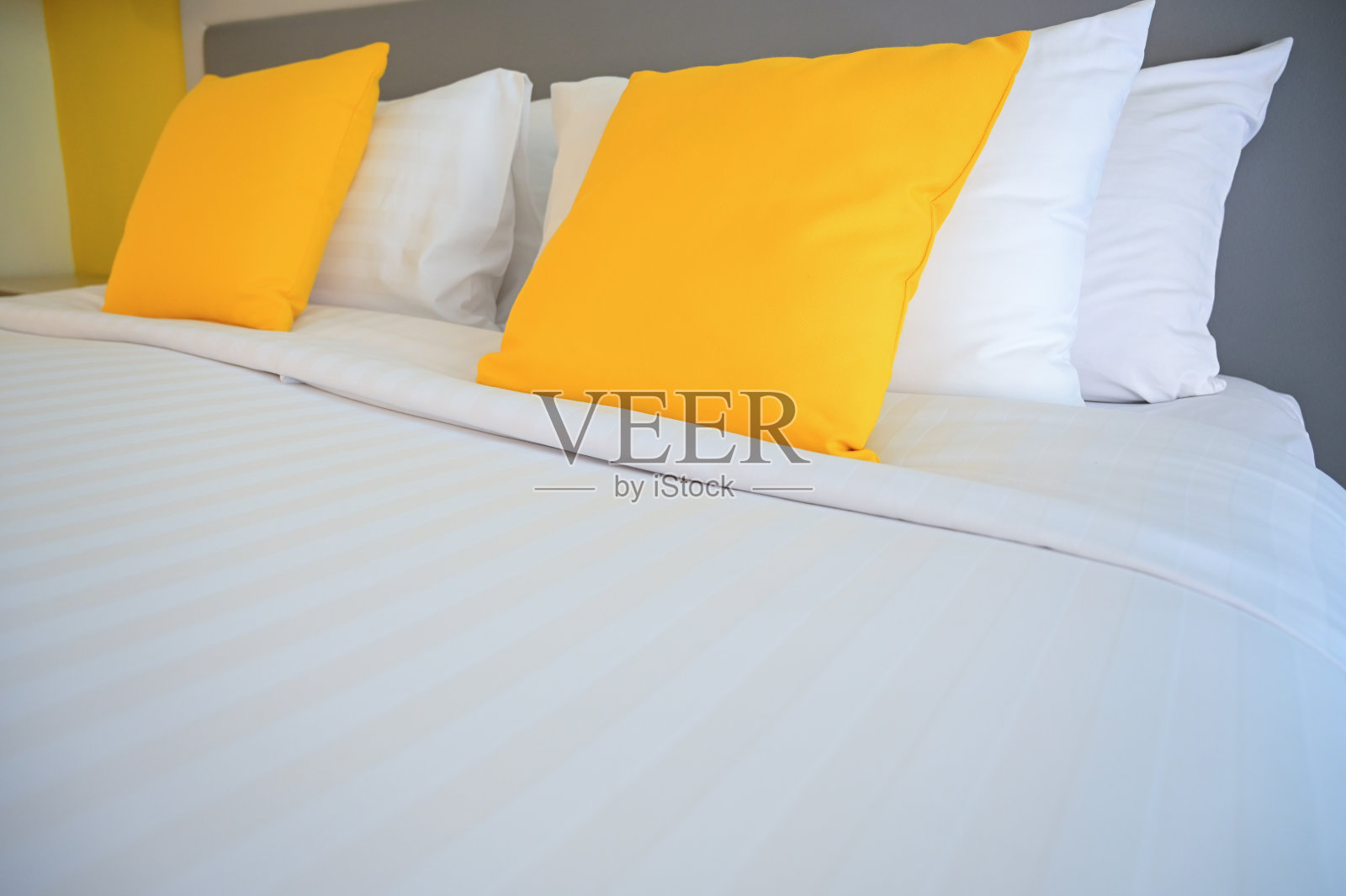 白色床上黄色枕头，室内设计照片摄影图片
