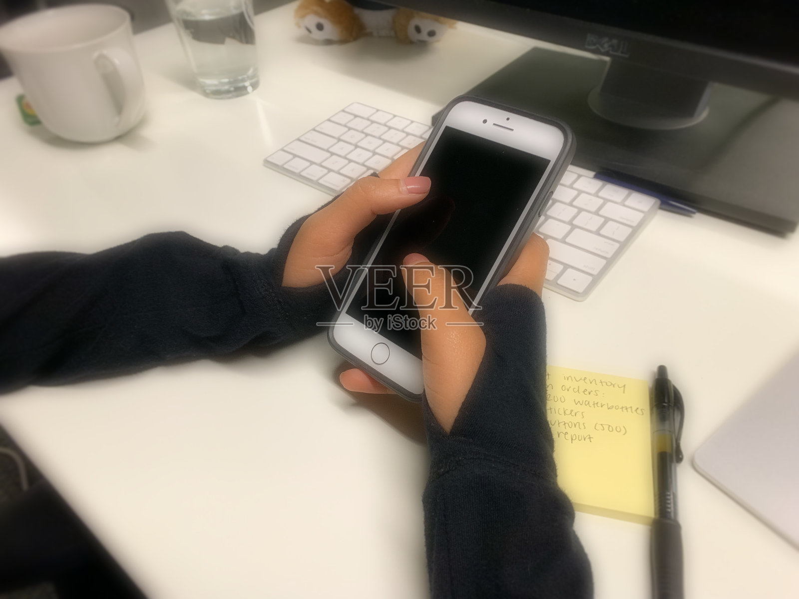 女士的手在桌子上拿着电话照片摄影图片