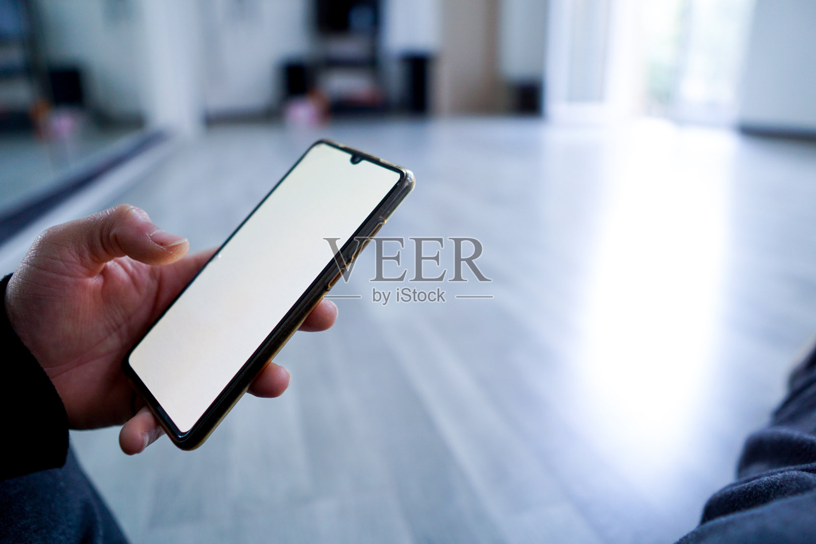 手里拿着手机，屏幕空白照片摄影图片