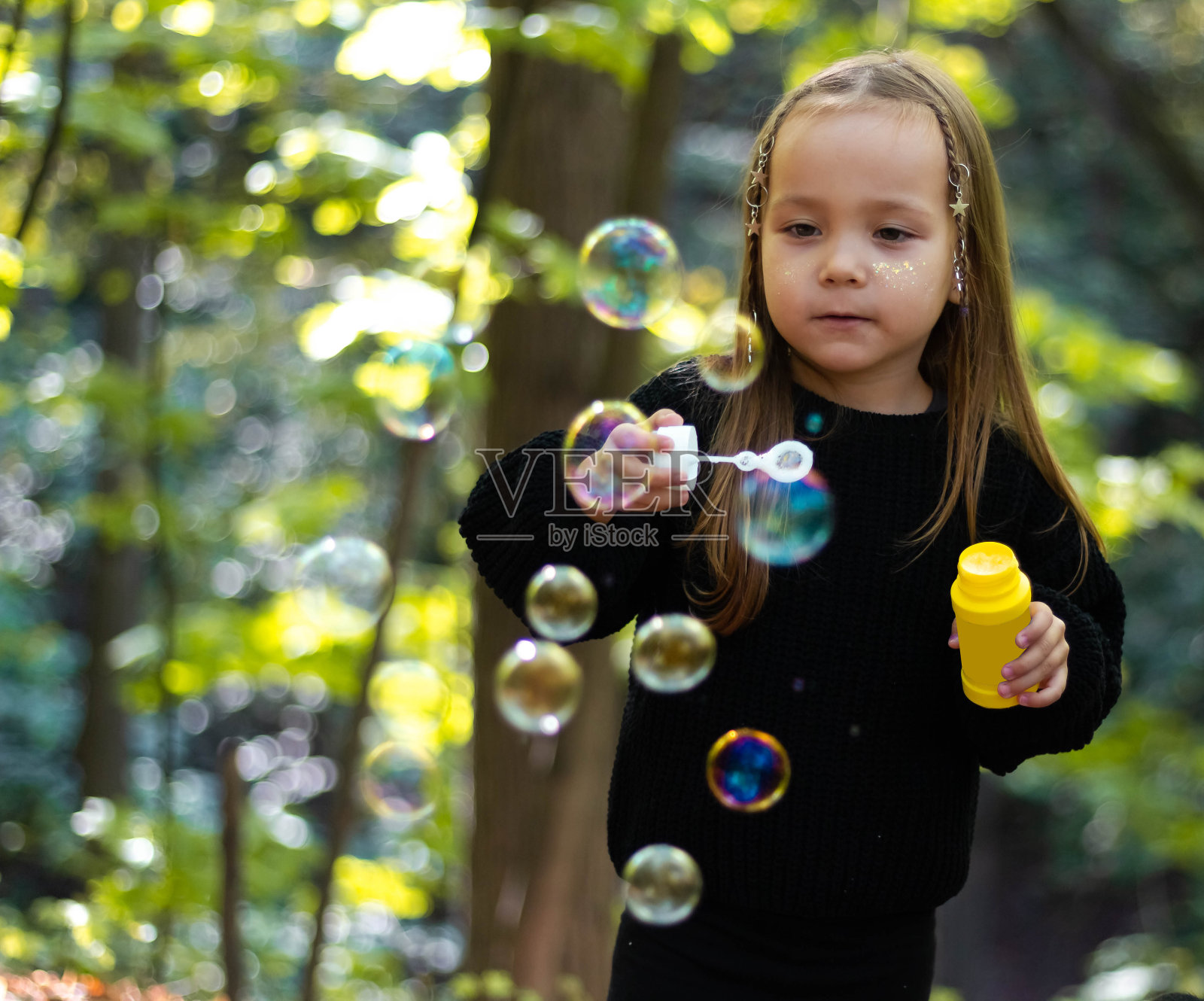 秋天的公园里玩肥皂泡的女孩。快乐的女孩。快乐的童年。照片摄影图片