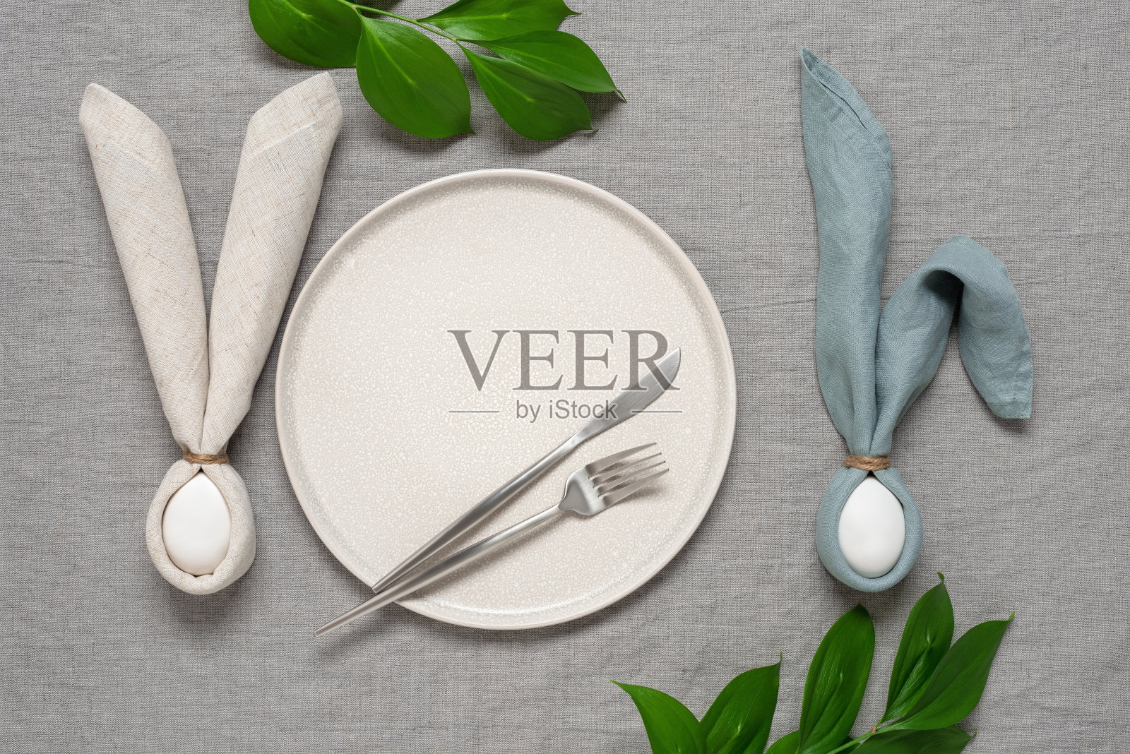 用亚麻餐巾和鸡蛋做成的复活节兔子的复活节餐桌。俯视图，平铺，复制空间。照片摄影图片