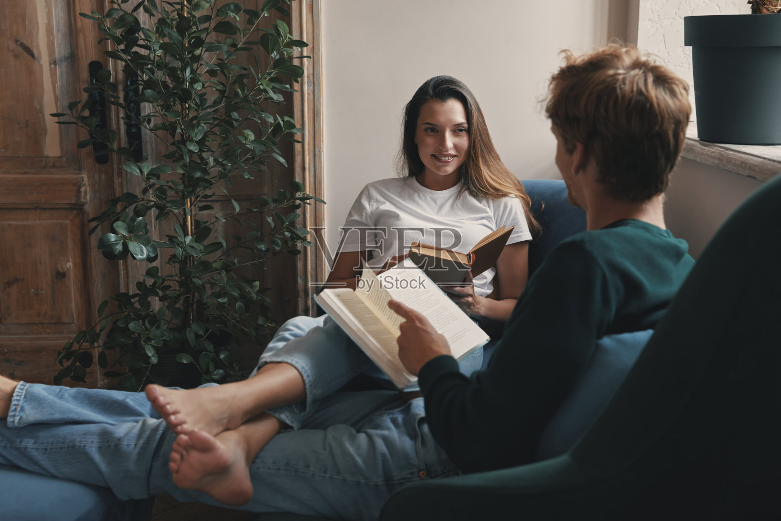 幸福的小夫妻在家里一起看书放松照片摄影图片