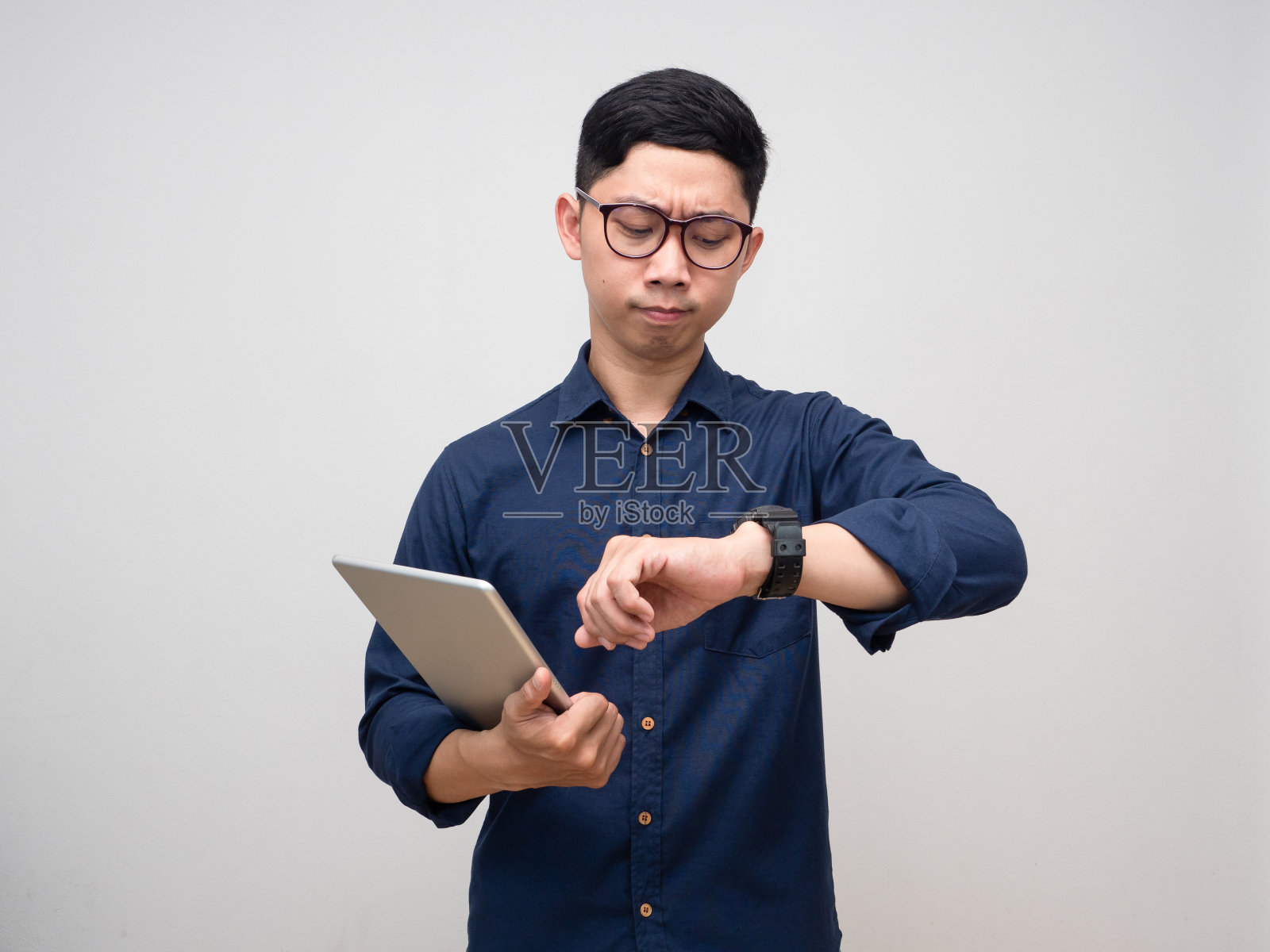 商人拿着平板看着自己的手表匆忙情绪孤立照片摄影图片