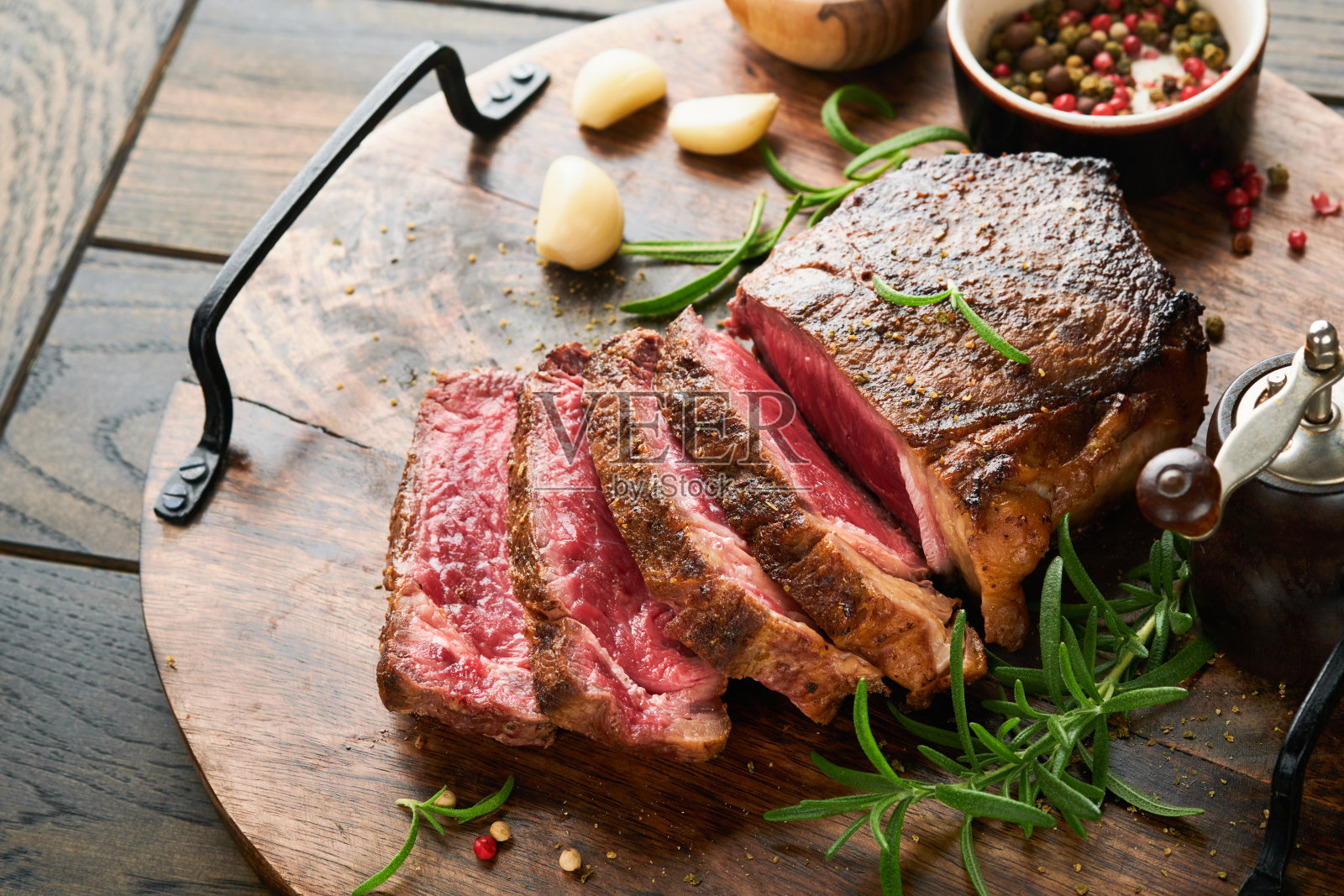 牛排。切片烤肉牛排纽约或Striploin与香料迷迭香和胡椒粉放在黑色大理石板上旧木背景。前视图。模拟。照片摄影图片