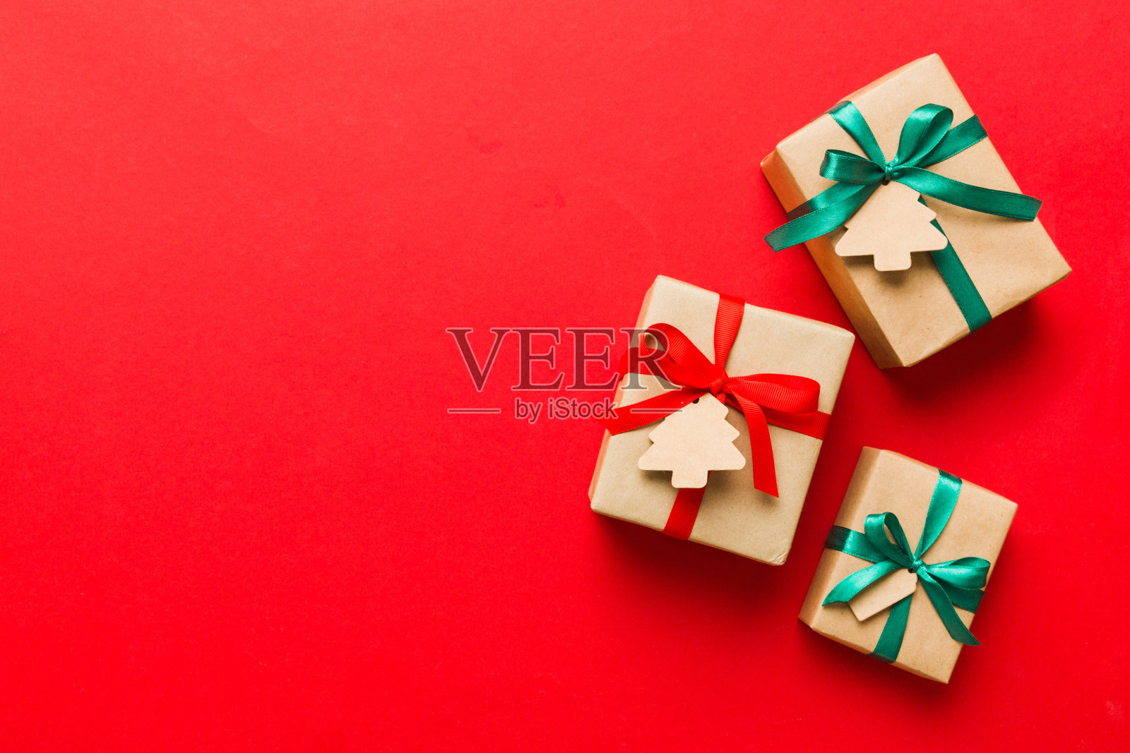 用彩色丝带用纸包装圣诞或其他节日手工制作的礼物。礼品盒，彩色桌子上的礼品装饰，顶视图与复制空间照片摄影图片