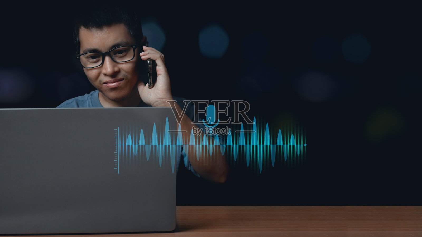 年轻人使用笔记本电脑和使用语音助手与智能手机通话以获取信息。照片摄影图片