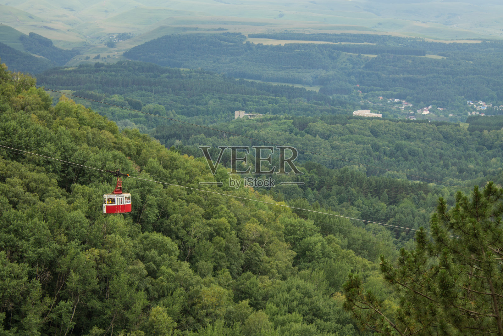 索道驾驶室的背景是一片绿树成荫的美丽山坡照片摄影图片