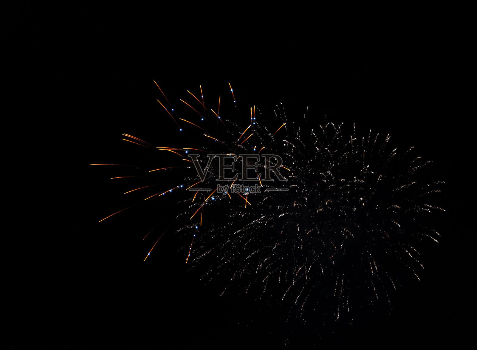 在黑暗的夜空中，低角度拍摄的发光的烟花照片摄影图片