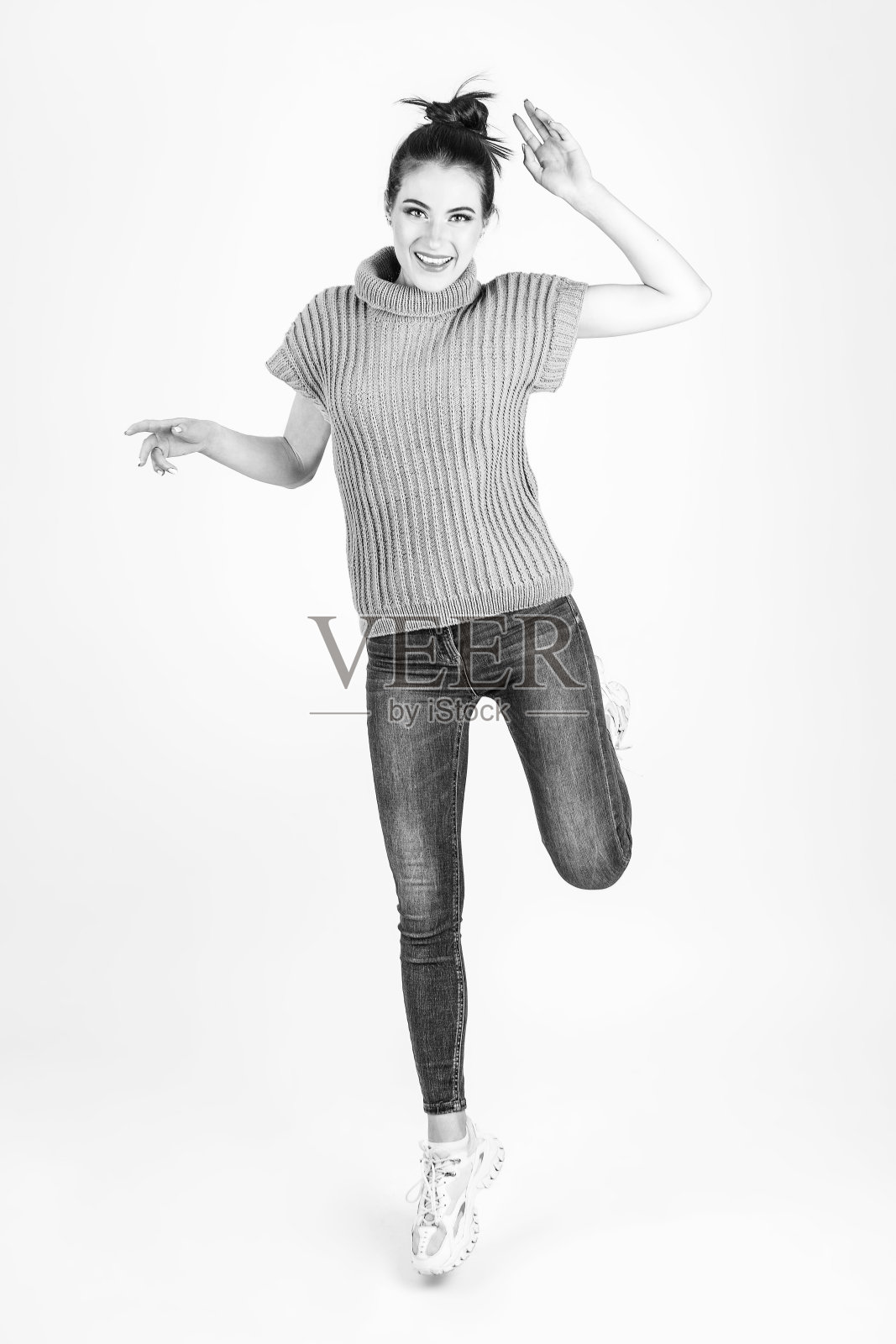 穿着蓝色无袖毛衣和蓝色牛仔裤的漂亮女人照片摄影图片