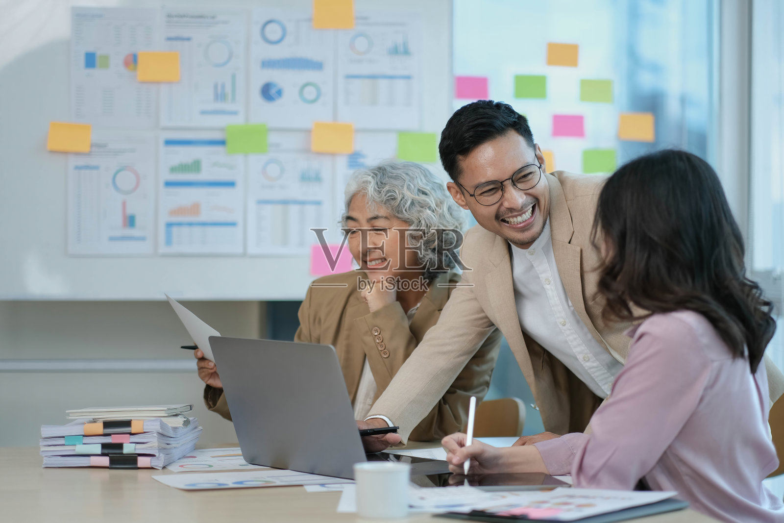 一群年轻的亚洲商业人士在办公室里集思广益，讨论合作的想法。照片摄影图片