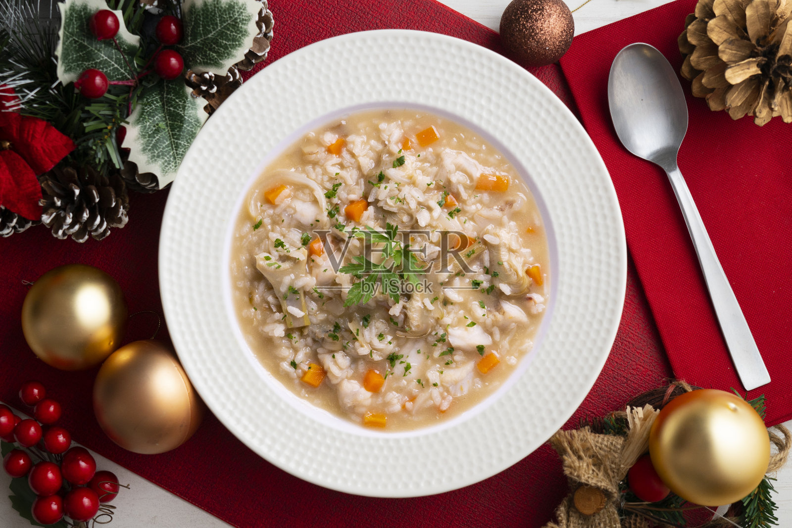 圣诞餐桌上的洋蓟汤饭。传统的西班牙海鲜汤食谱。照片摄影图片