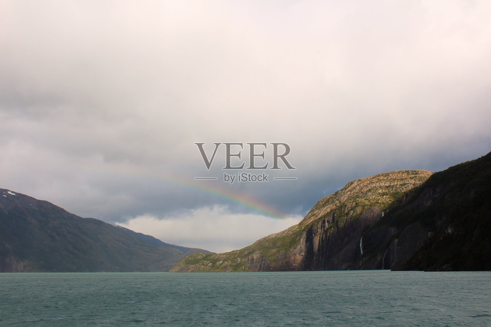 在智利巴塔哥尼亚的贝尔纳多·奥希金斯国家公园，一个多云的日子里，Ultima Esperanza峡湾的美丽景色和彩虹。照片摄影图片