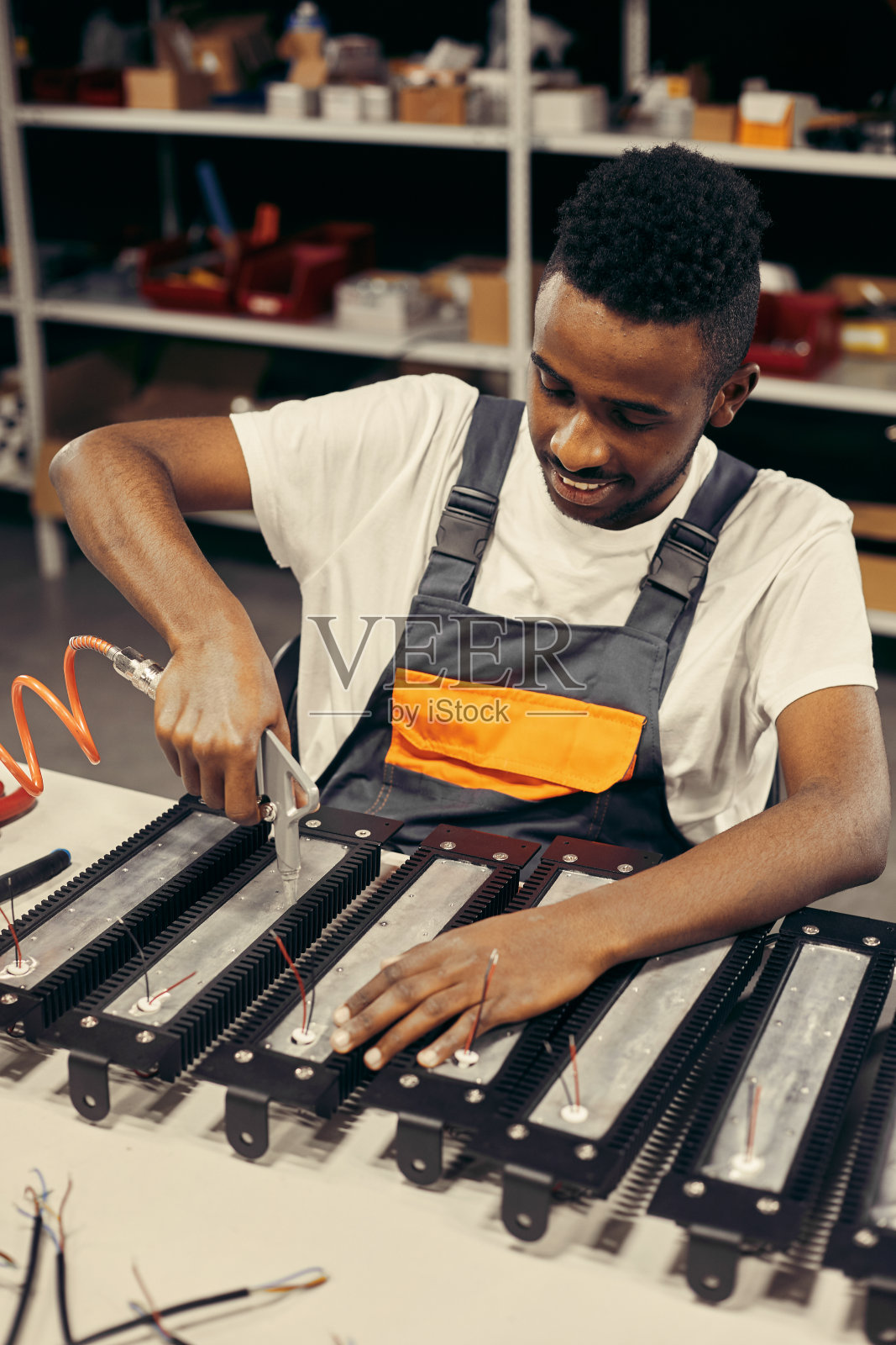 男性工厂工人使用电动螺丝刀照片摄影图片